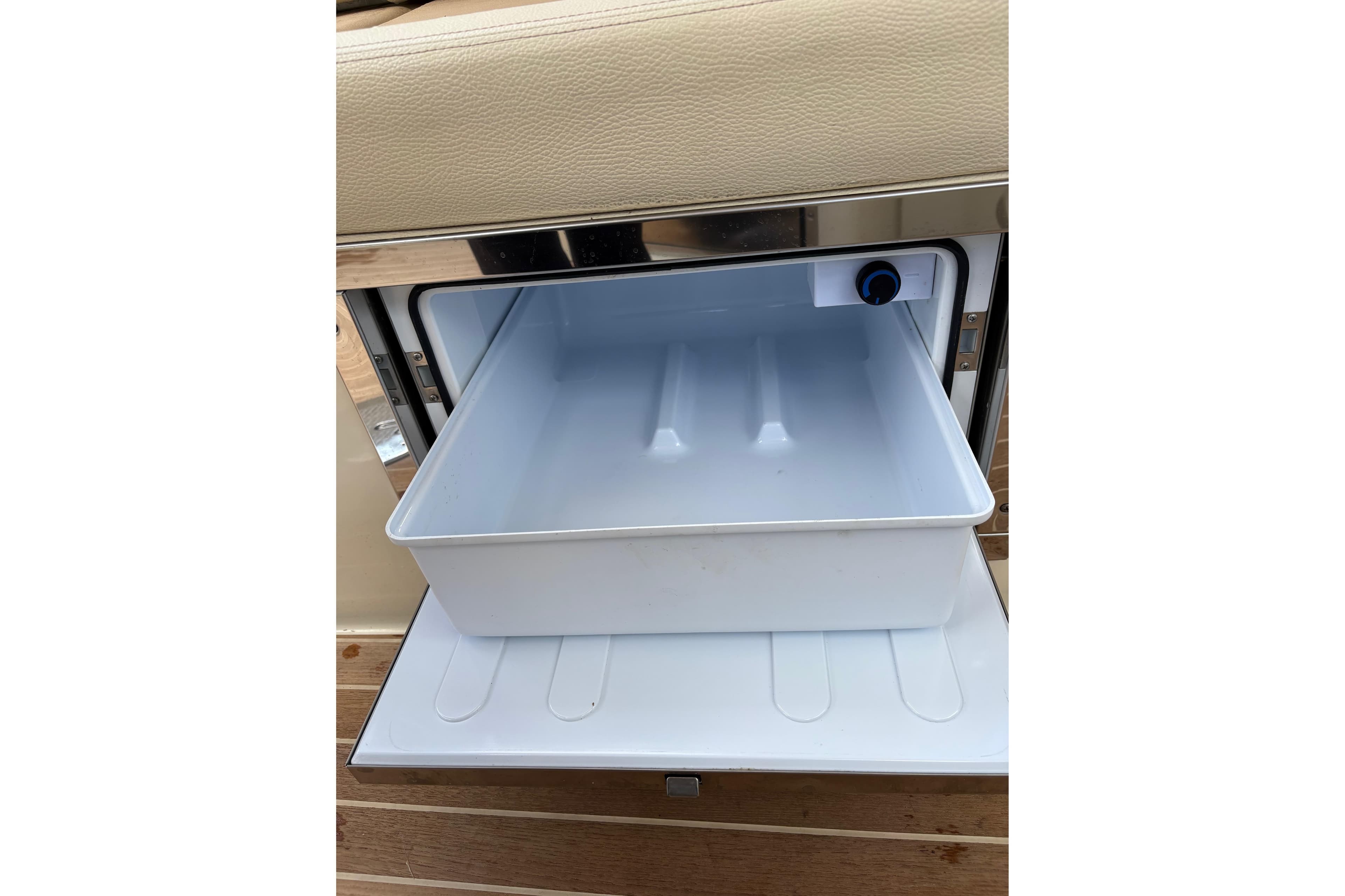 2022 Chris-Craft Launch 28 GT cooler compartment with beige upholstery and wooden flooring.