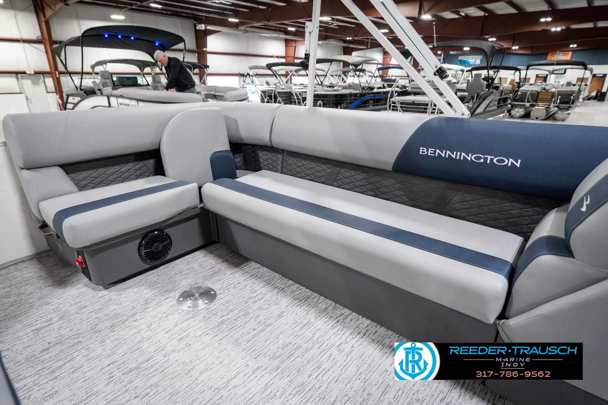 2025 Bennington 22 SLS pontoon boat interior with gray seating in showroom.