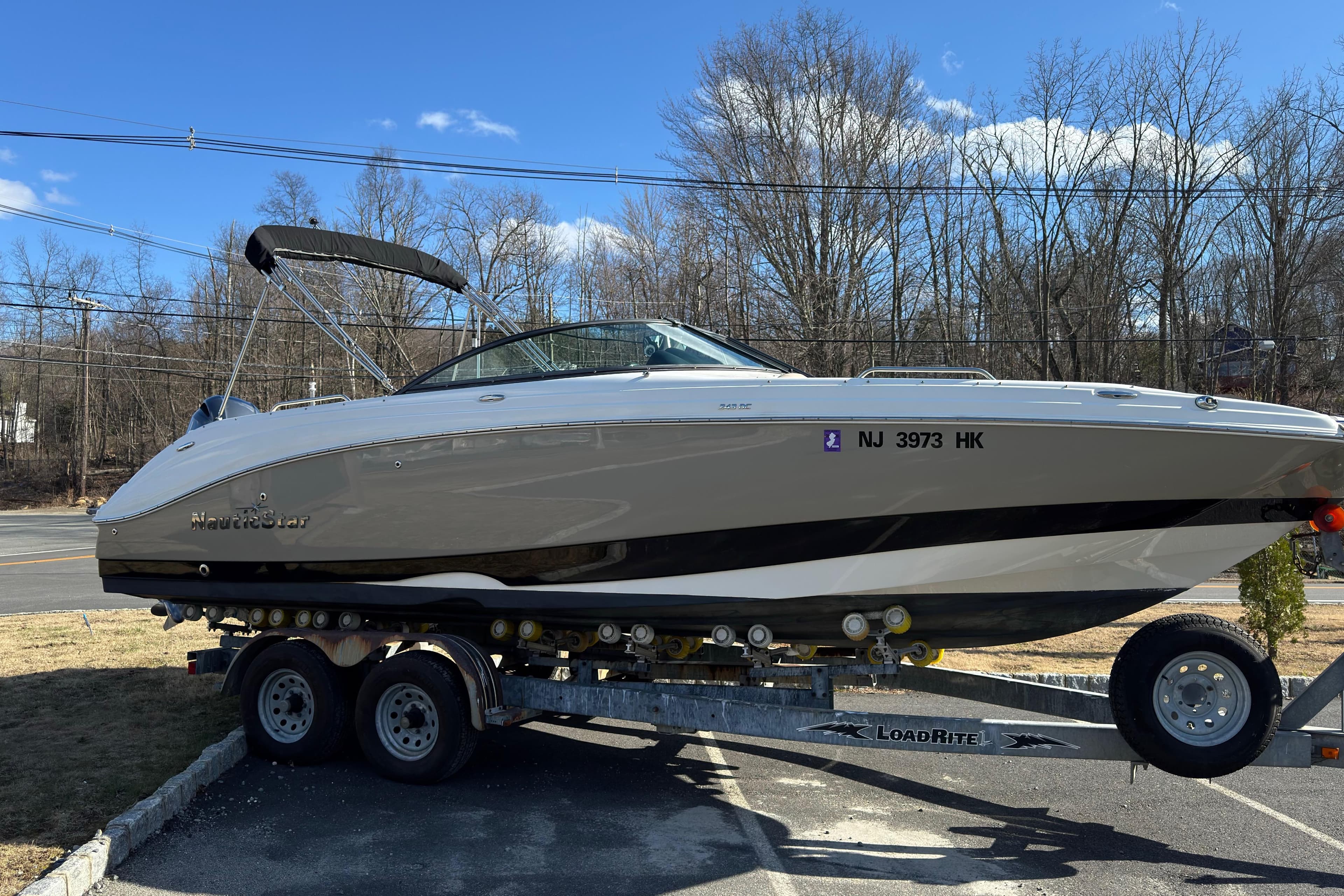 2017 NauticStar 243DC Sport Deck boat on trailer, parked outdoors.