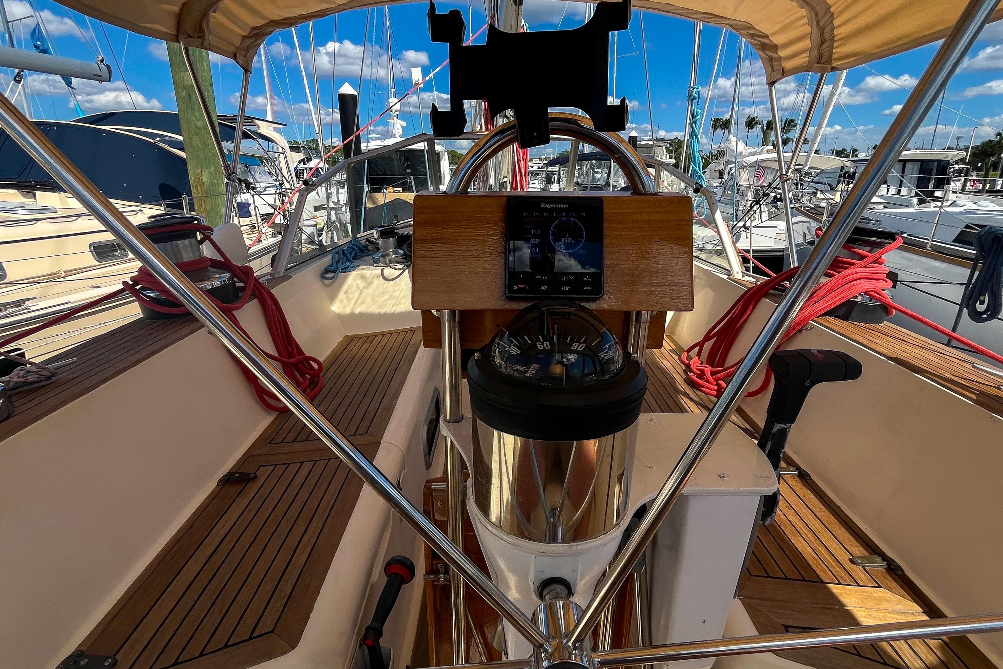 Cockpit of 1991 Oyster LW48 sailboat with navigation equipment and wooden deck.