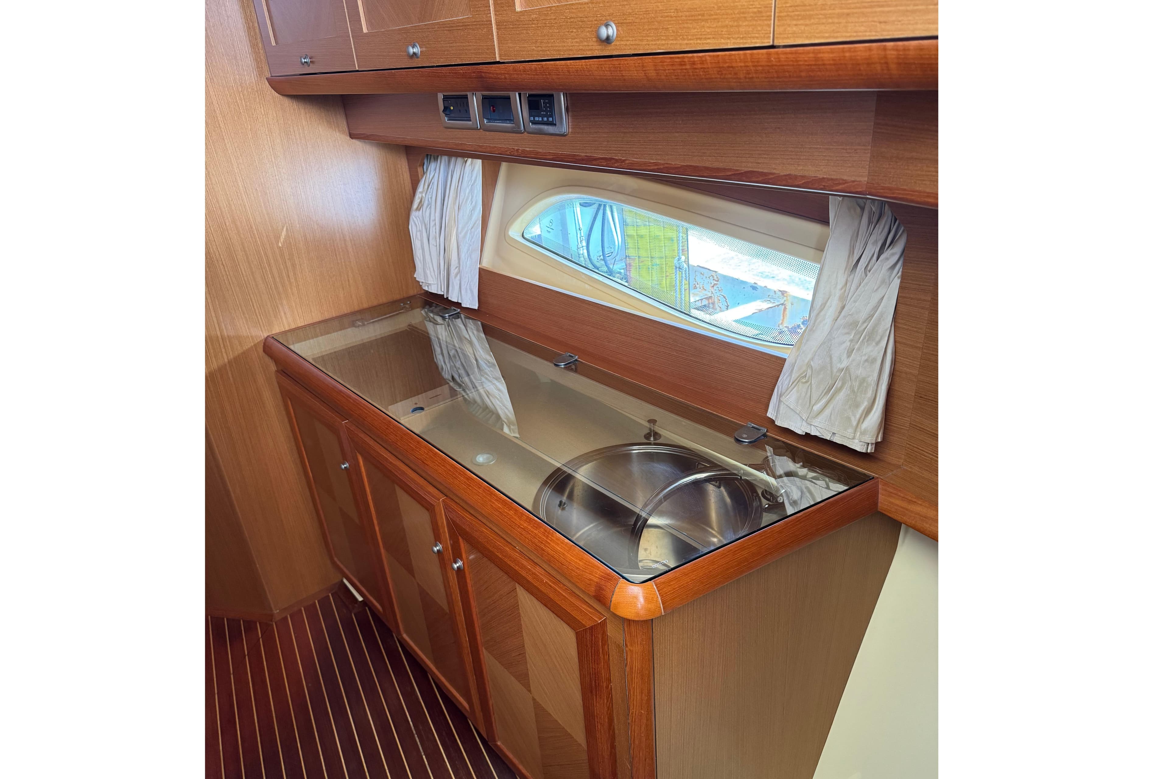Interior of 2009 Mochi Craft 44 Dolphin yacht with wooden cabinetry and sink.