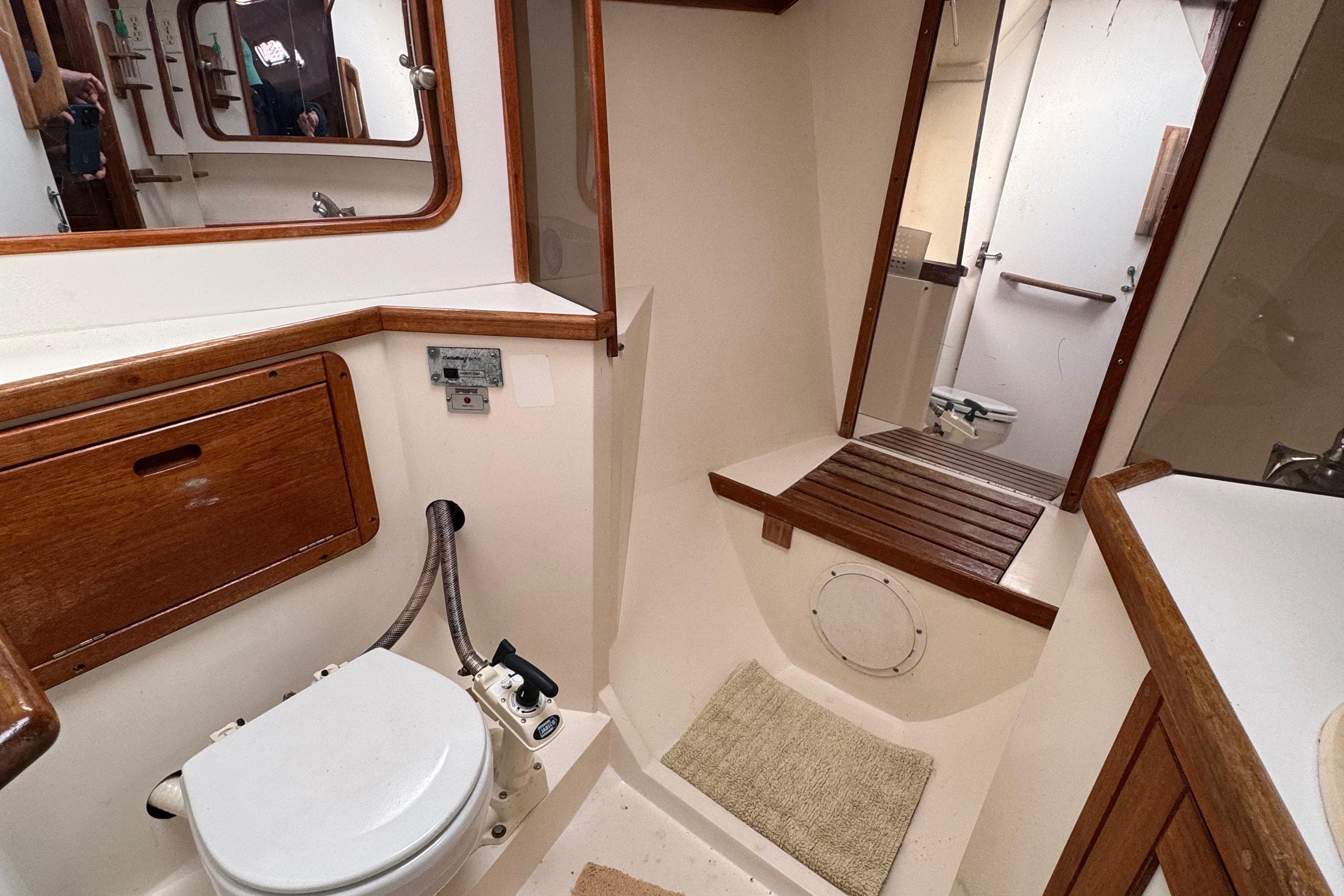 Bathroom interior of a 1989 Catalina 42 sailboat, featuring wooden accents and compact design.