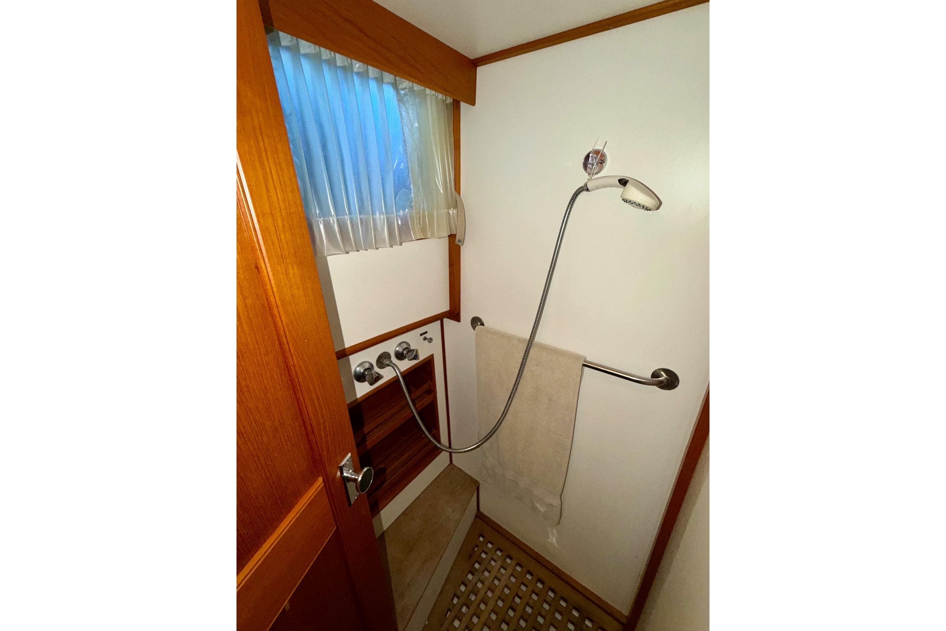 Shower area in 1991 Grand Banks 36 Europa yacht with wooden accents and towel rail.