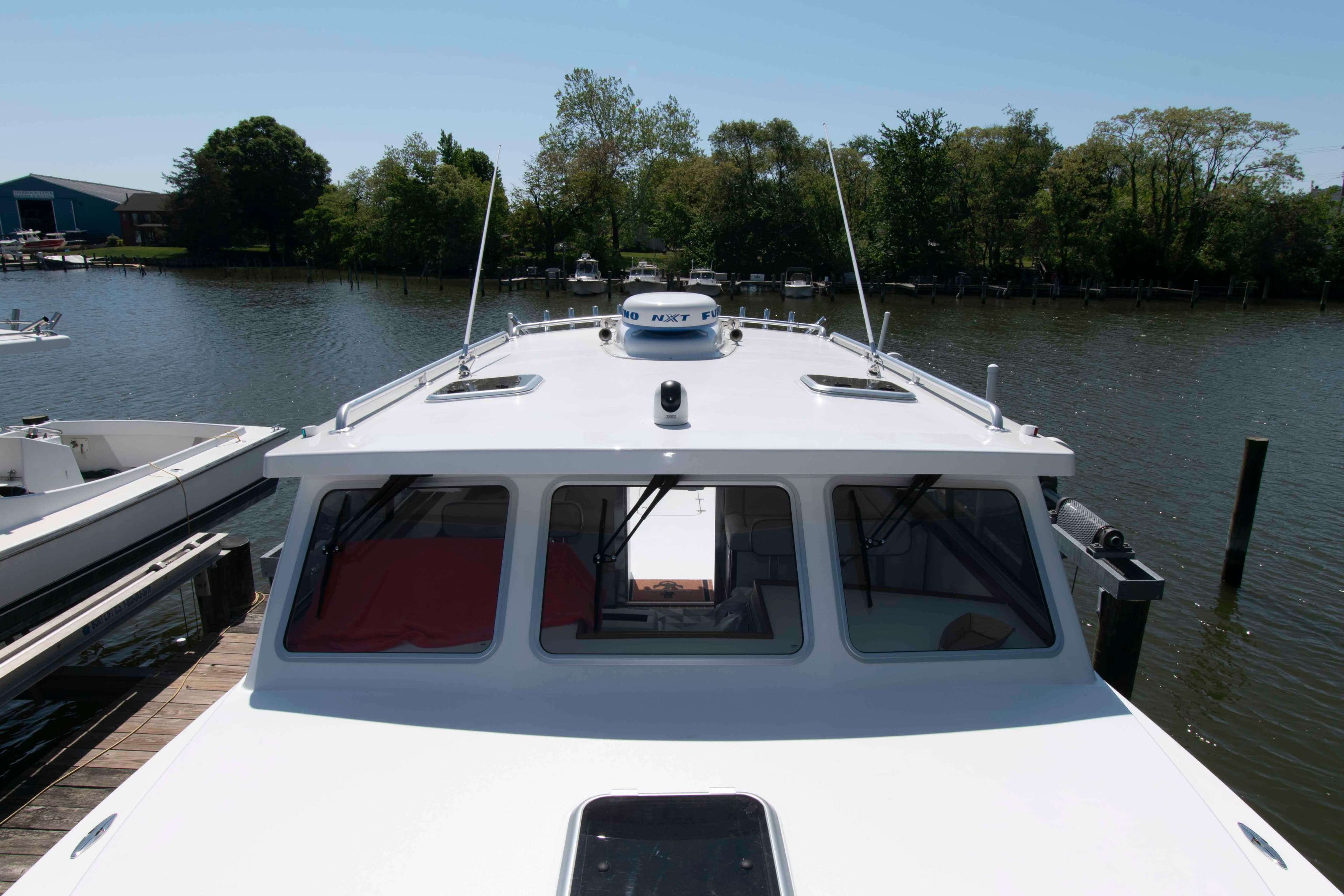 2024 Composite Yacht CY 42 docked on a serene river, surrounded by lush greenery.