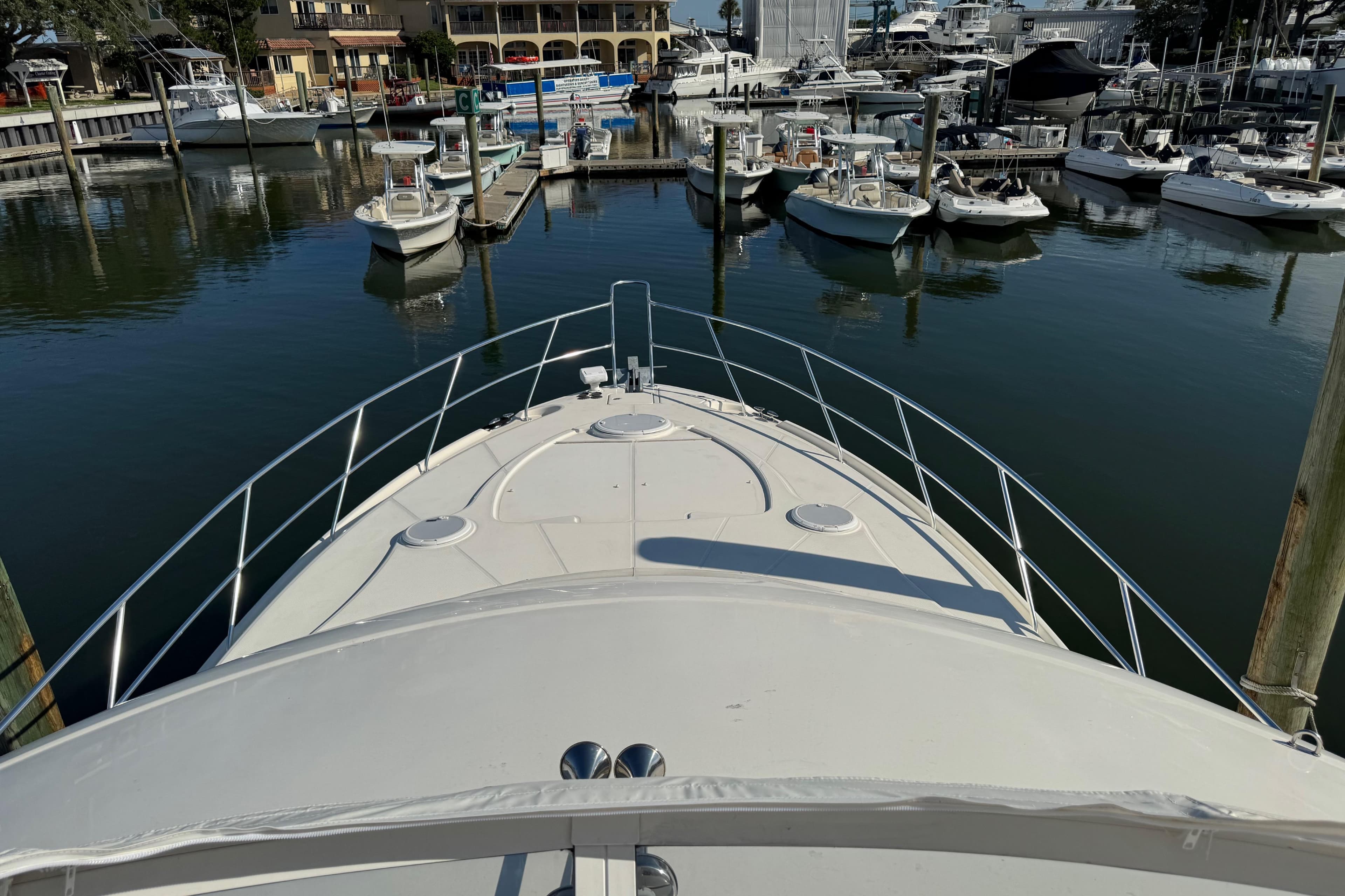 Bow view of 2009 Ovation 52 yacht docked in a marina with surrounding boats.