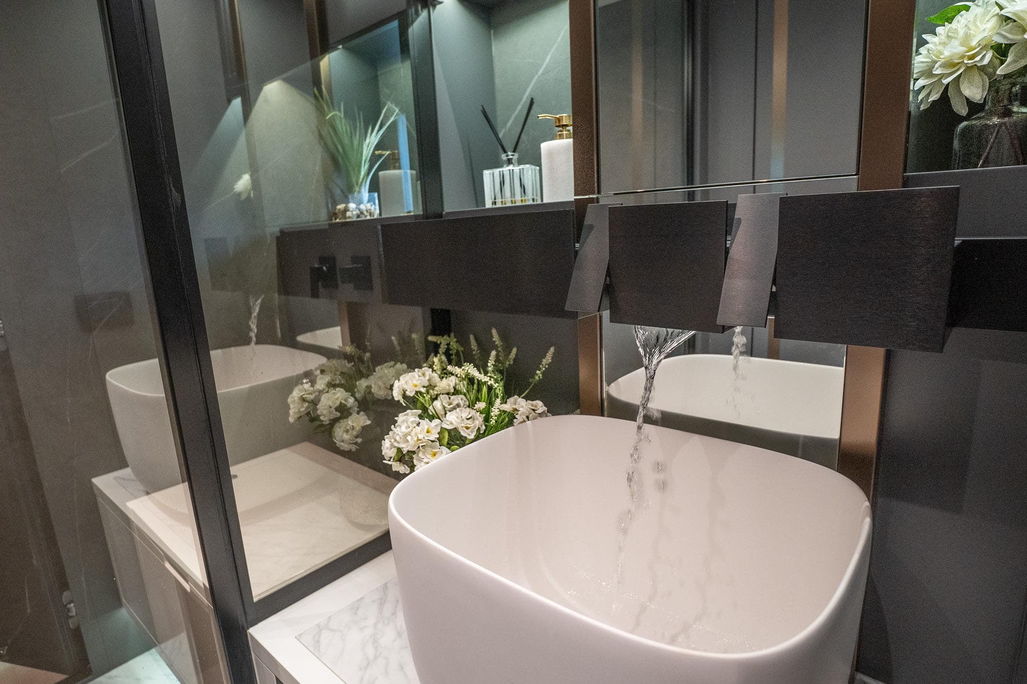 Modern bathroom with sleek sink, flowing water, and elegant decor, featuring Explorer EX62, 2024.