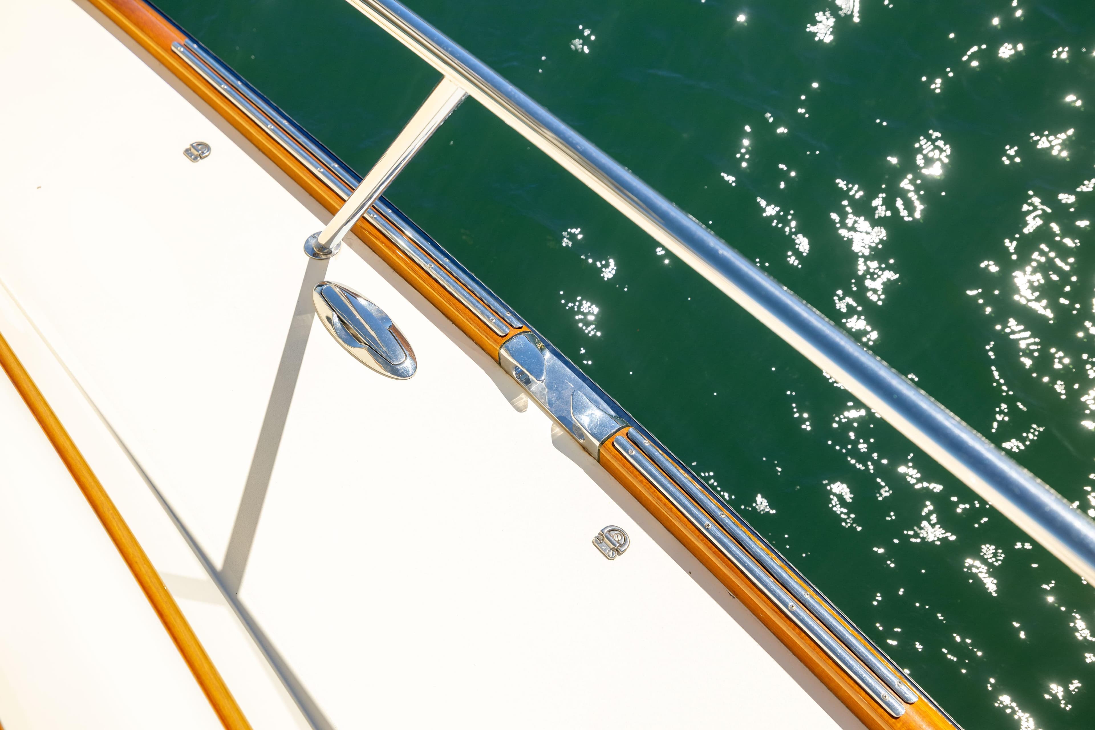 Hinckley Talaria 48 Flybridge 2014 yacht deck with polished railing over sparkling water.