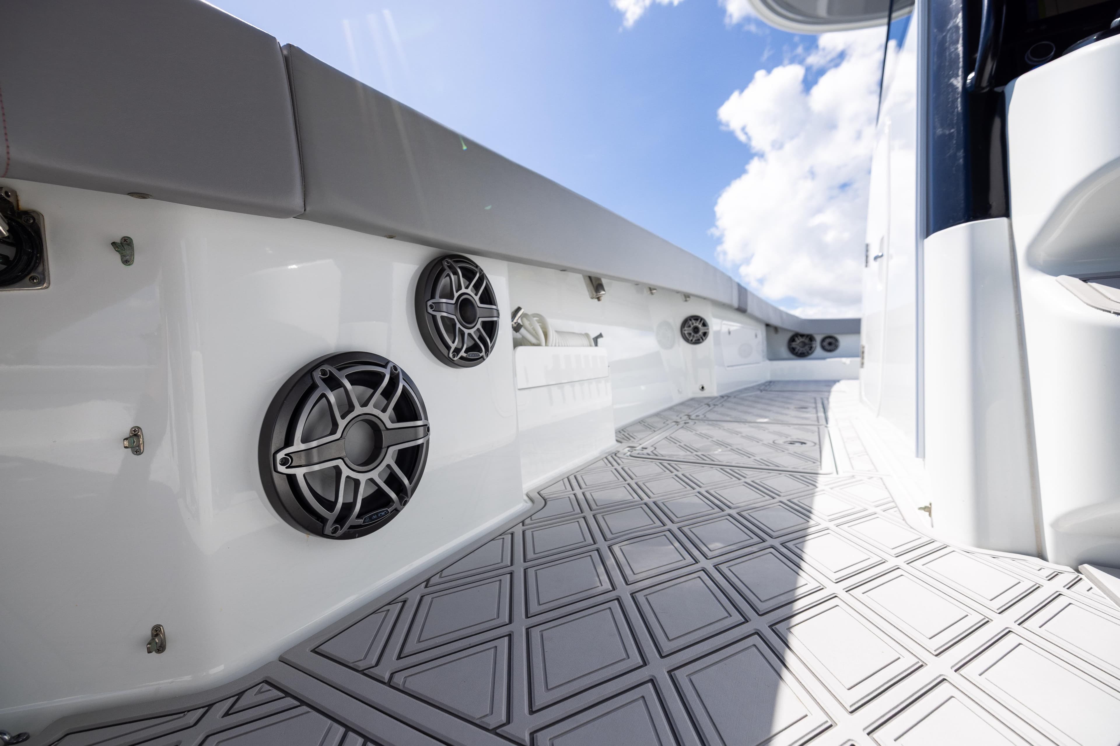 2023 Freeman 47 boat deck with speakers and patterned flooring under a blue sky.