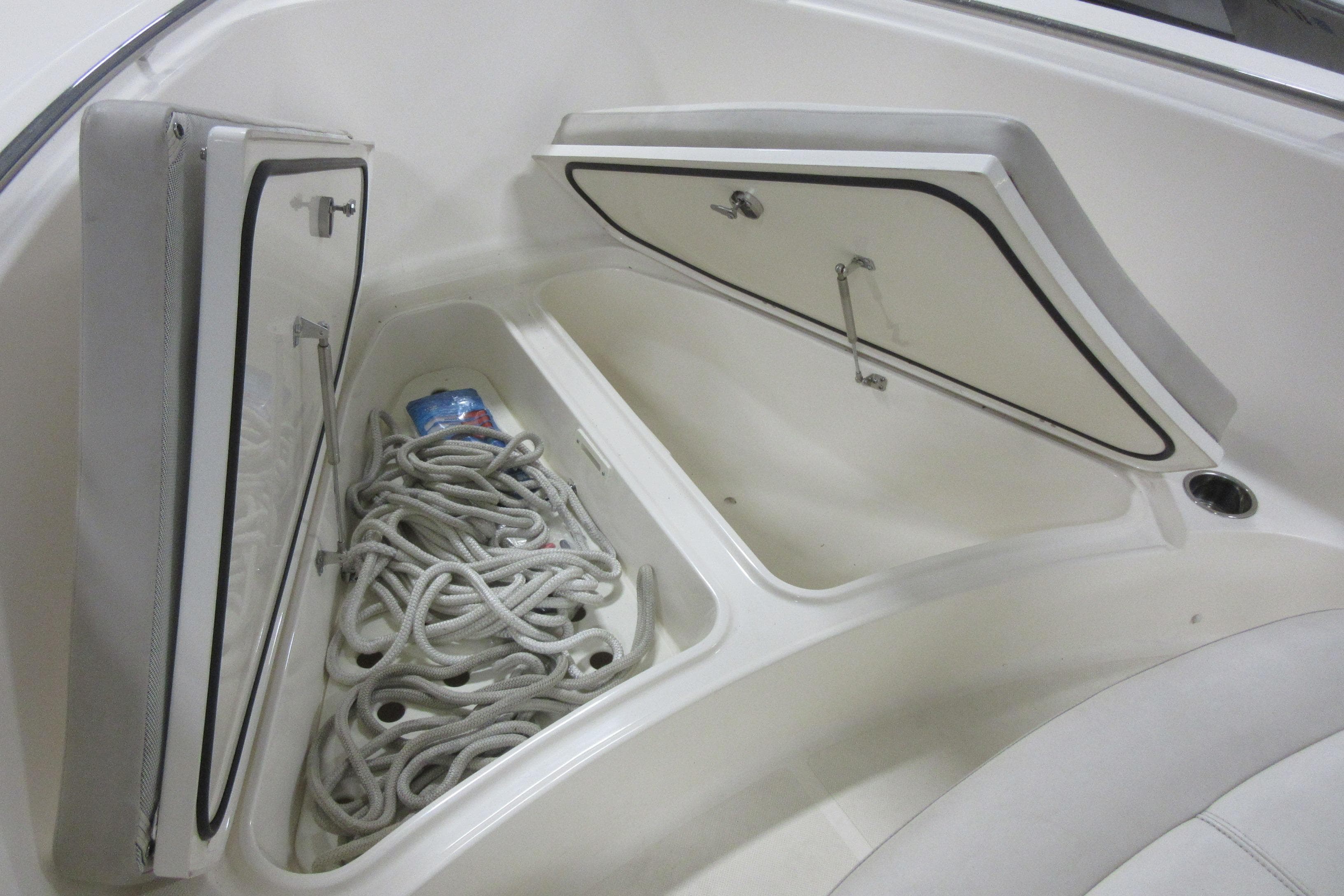 2011 Pursuit C 230 Center Console boat storage compartments with rope and drink can.