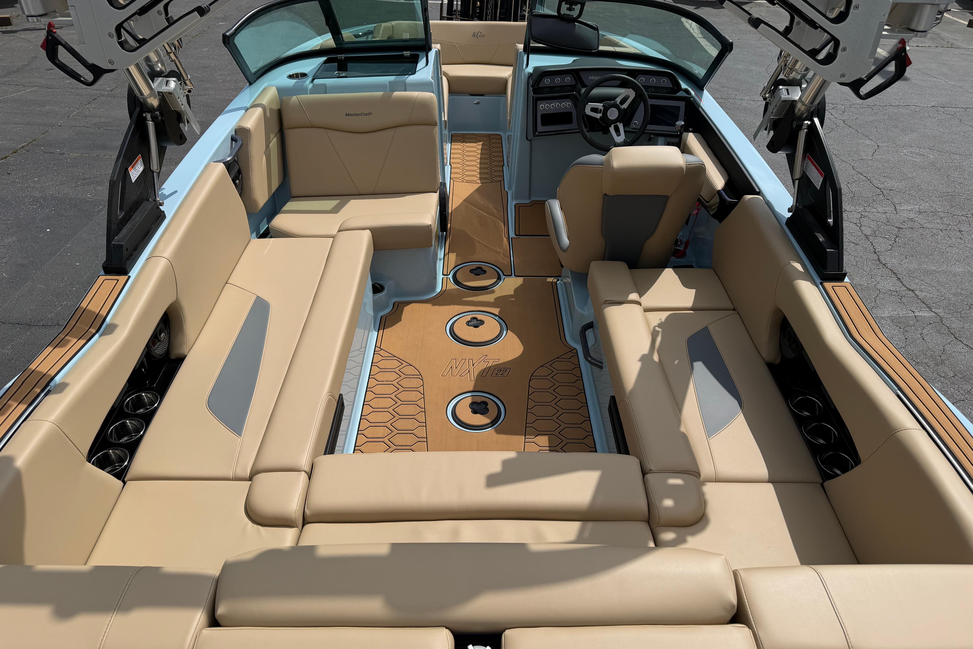 2025 MasterCraft NXT22 boat interior with beige seating and modern dashboard design.