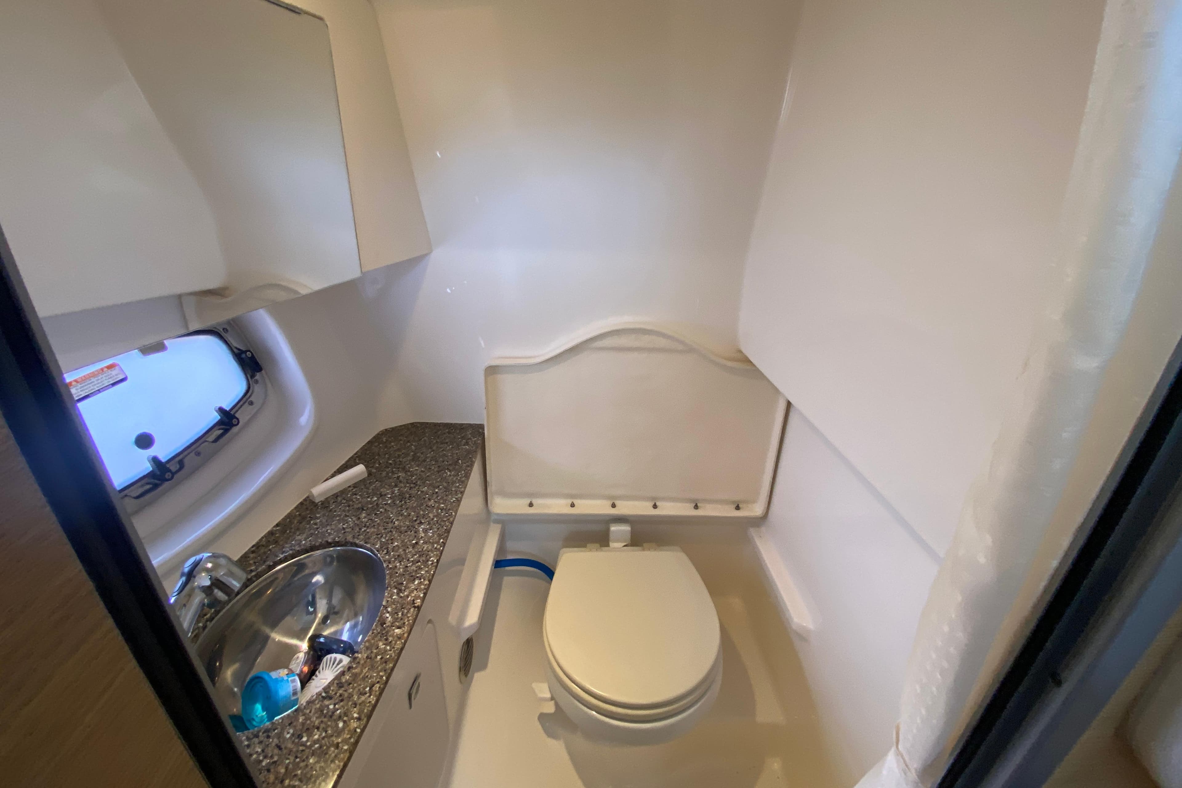 Compact bathroom in 2012 Chaparral 327 SSX boat with sink and toilet.