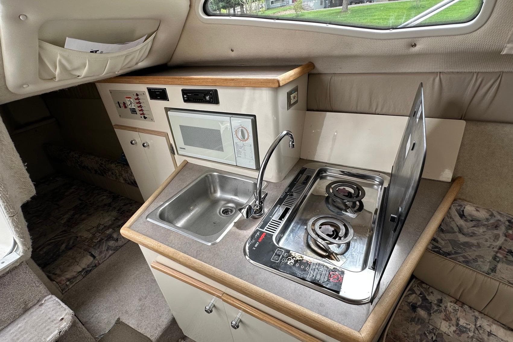 1997 Bayliner 2655 Ciera Sunbridge interior with kitchenette, featuring sink, stove, and microwave.