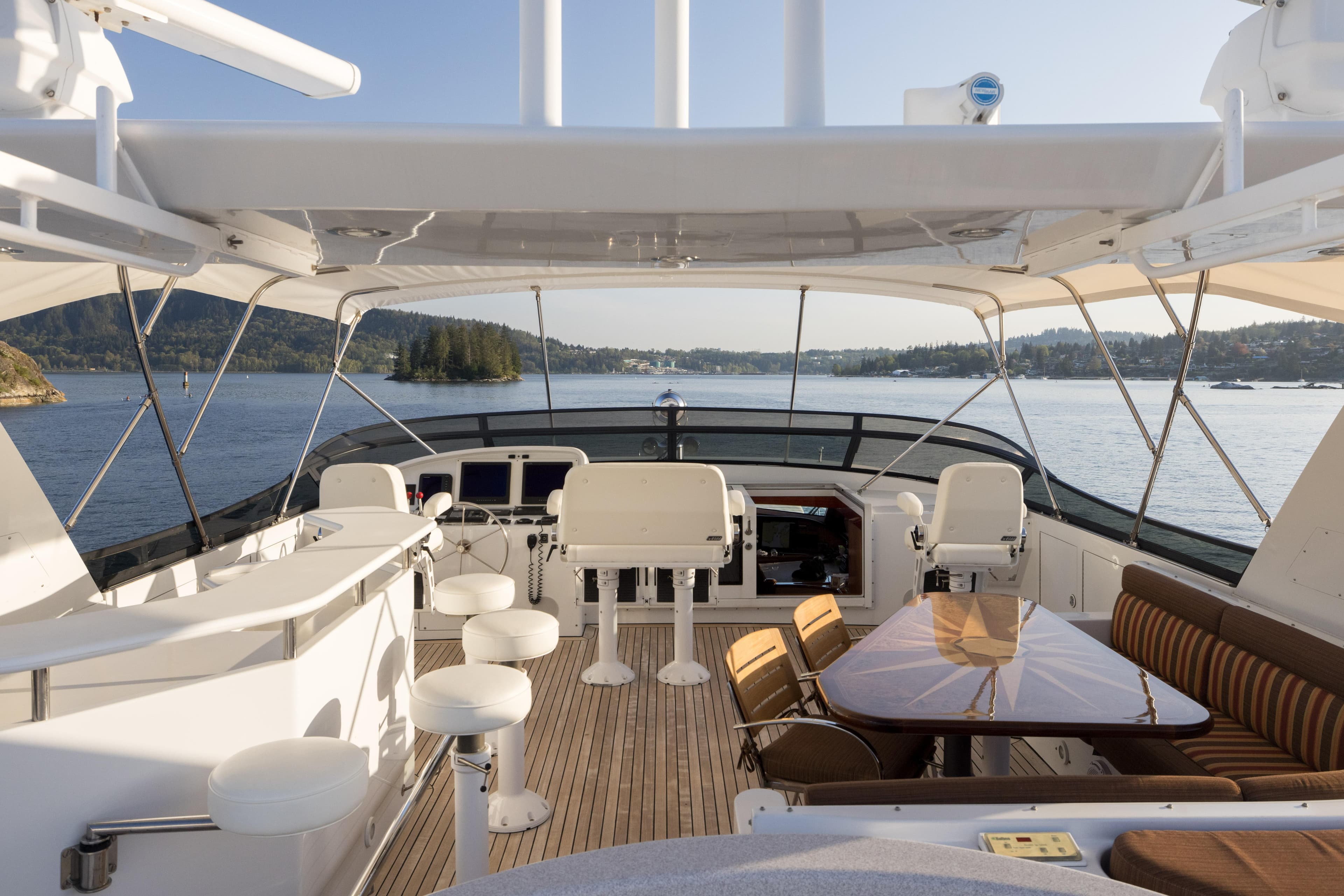 Luxurious 2000 Westport Crescent yacht deck with seating, bar stools, and scenic water view.
