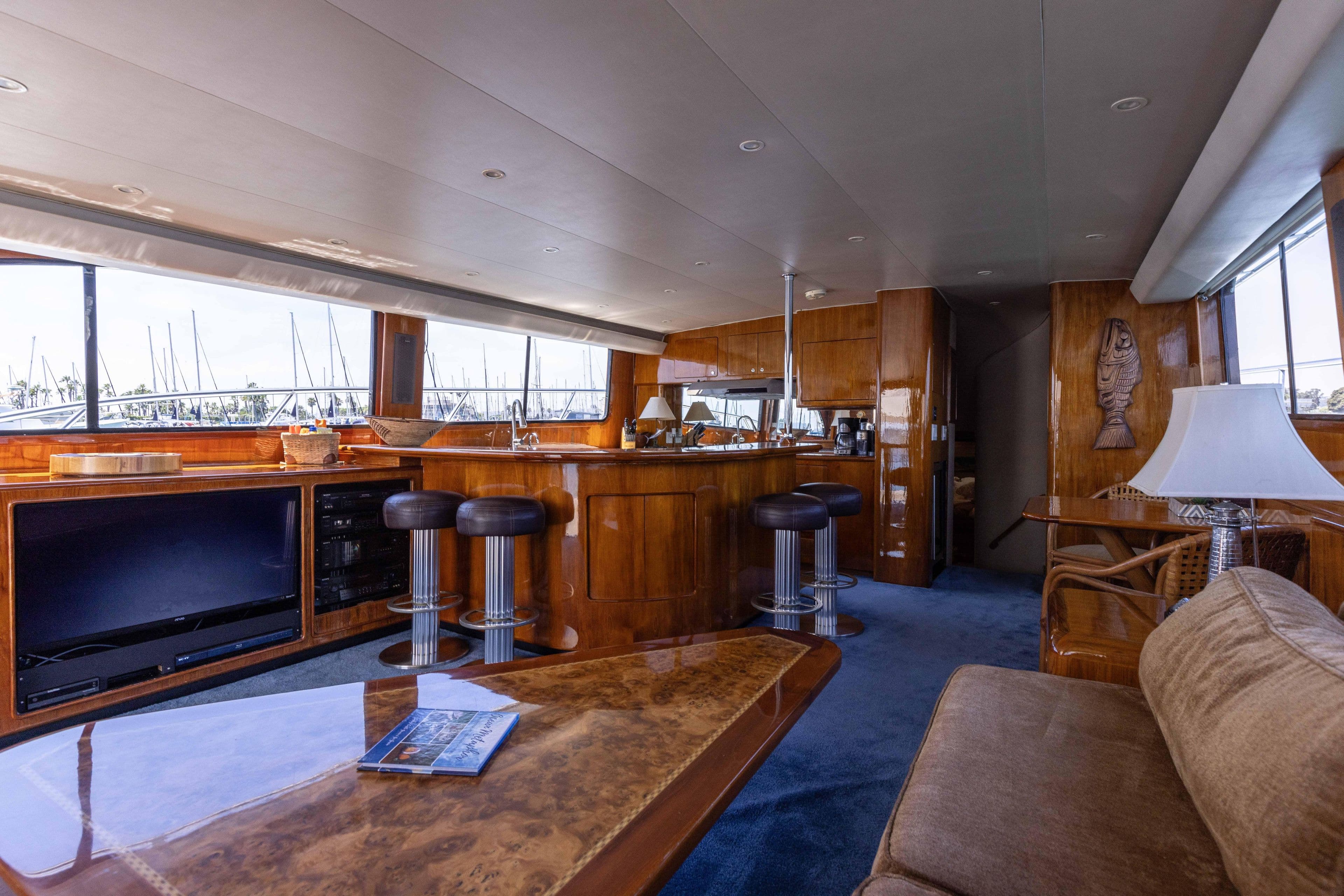 Luxurious 1988 Donzi yacht interior with wooden bar, stools, and plush seating.