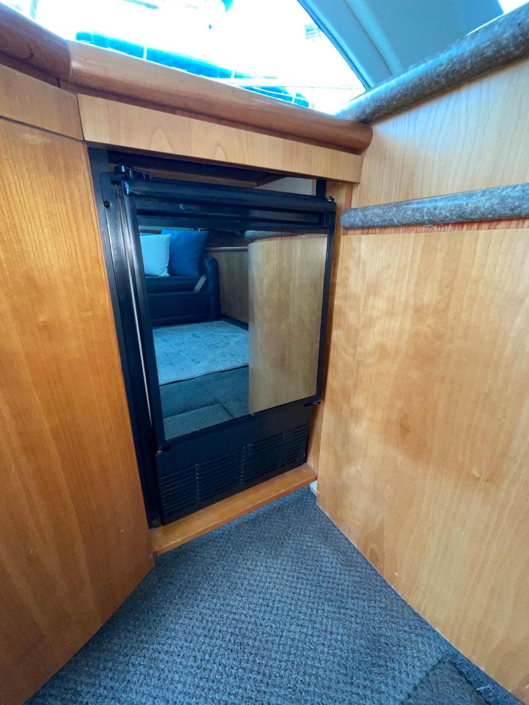 1997 Maxum 4600 Custom SCB yacht interior with compact refrigerator and wooden cabinetry.