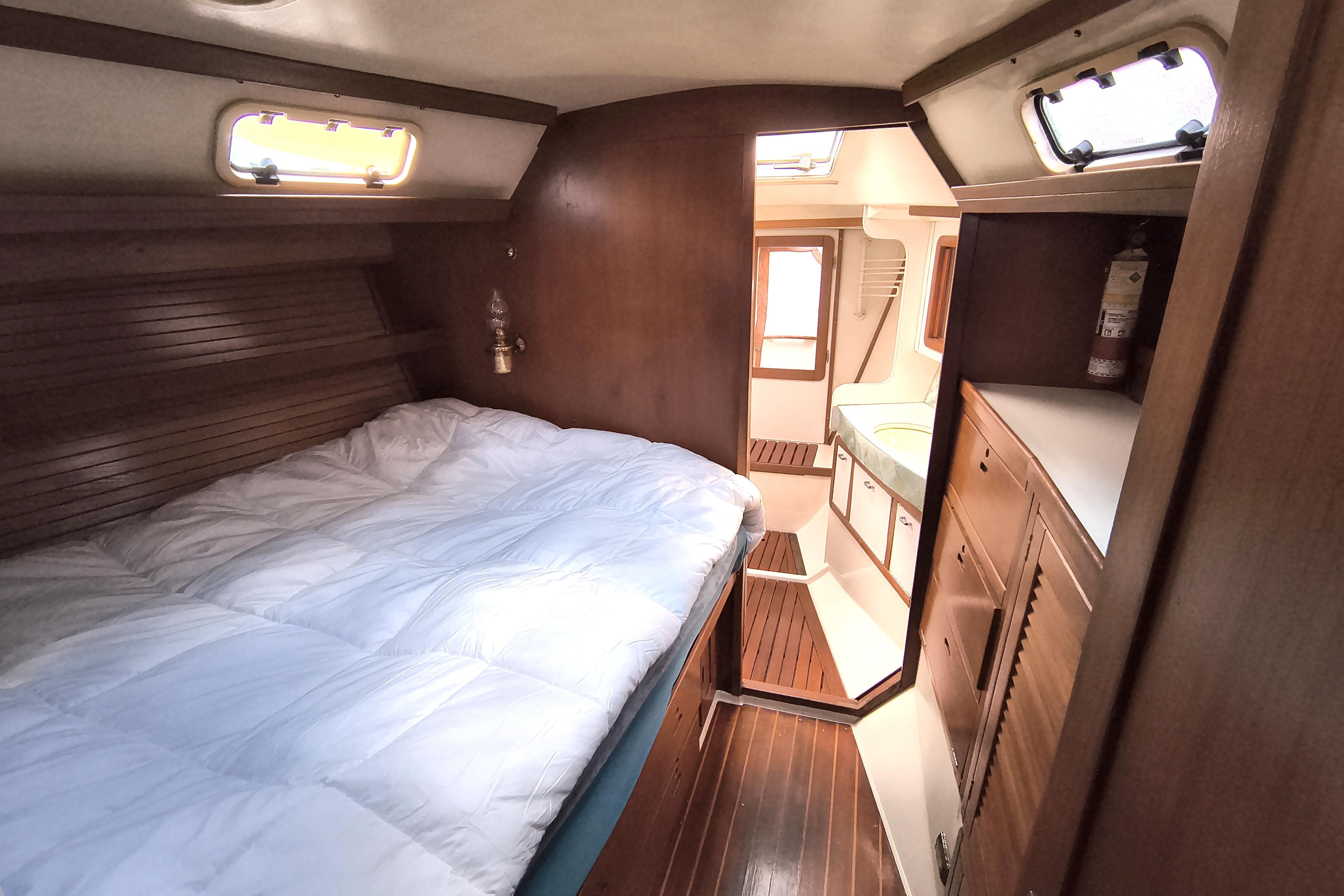 Cozy cabin interior of a 1993 Catalina 42 sailboat with wooden furnishings.