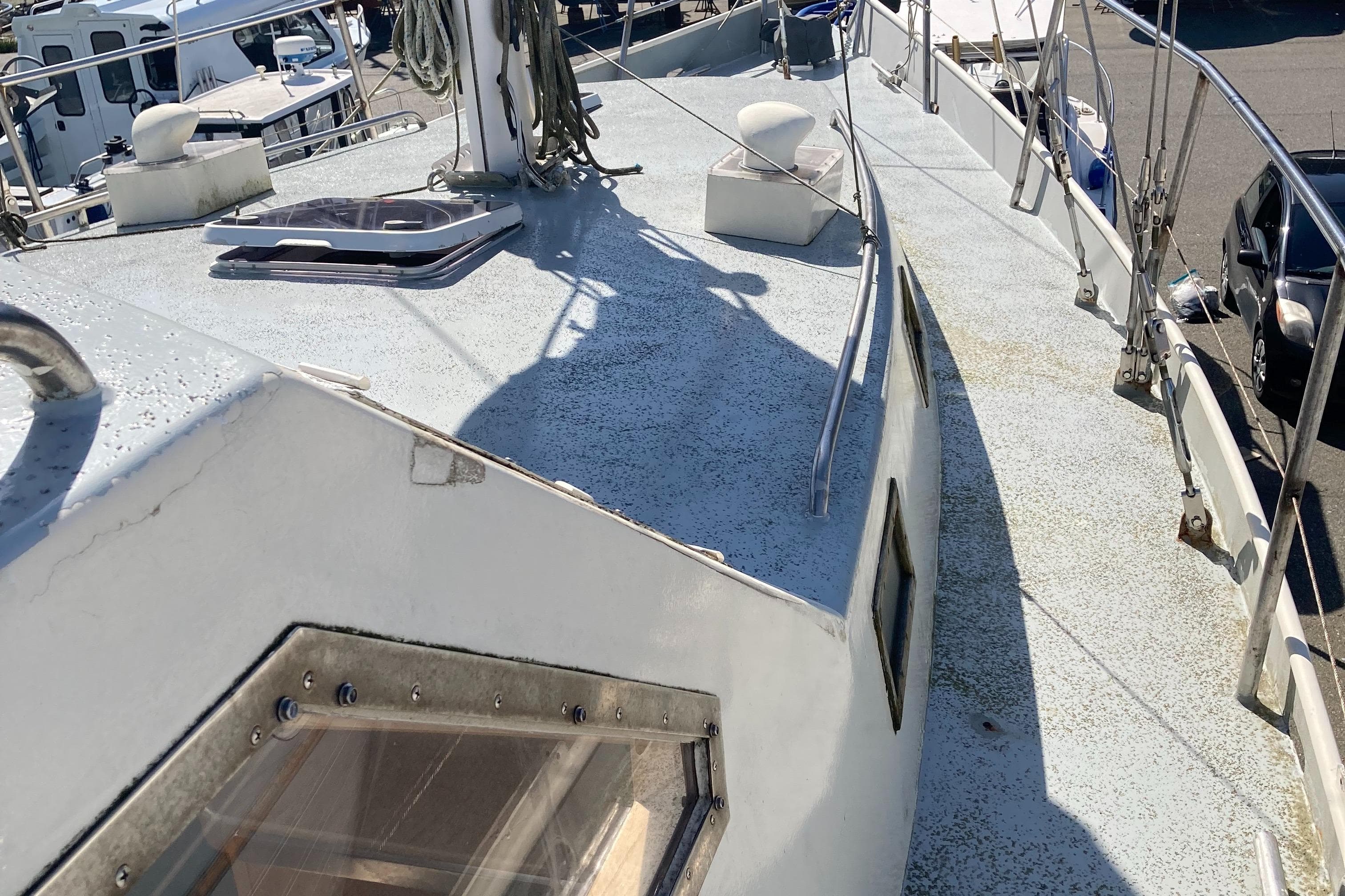 1991 Bruce Roberts Pilothouse sloop deck with railing and hatch, docked in marina.