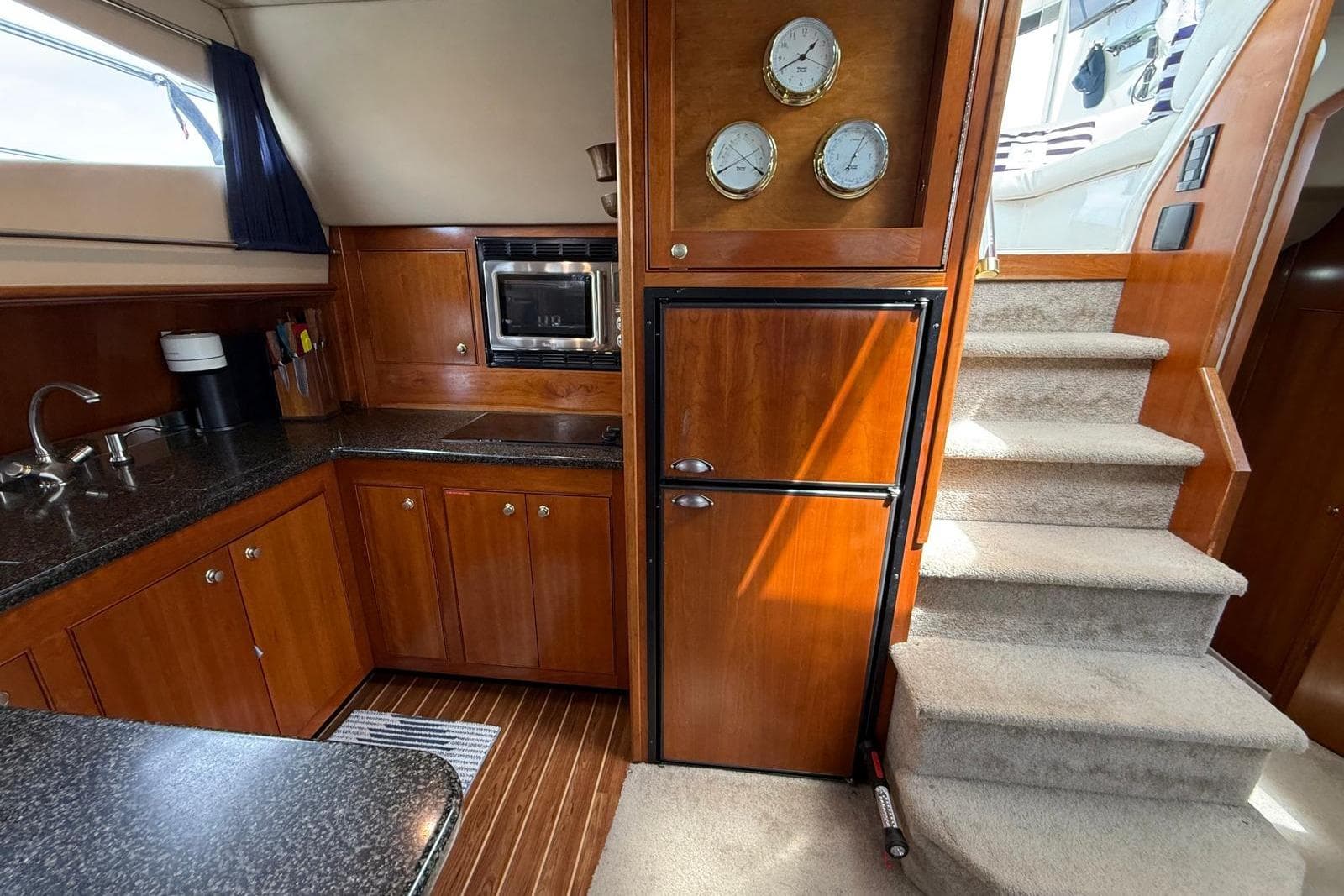 Luxurious 2005 Cruisers Yachts 455 Express Motoryacht interior with kitchen and stairs.