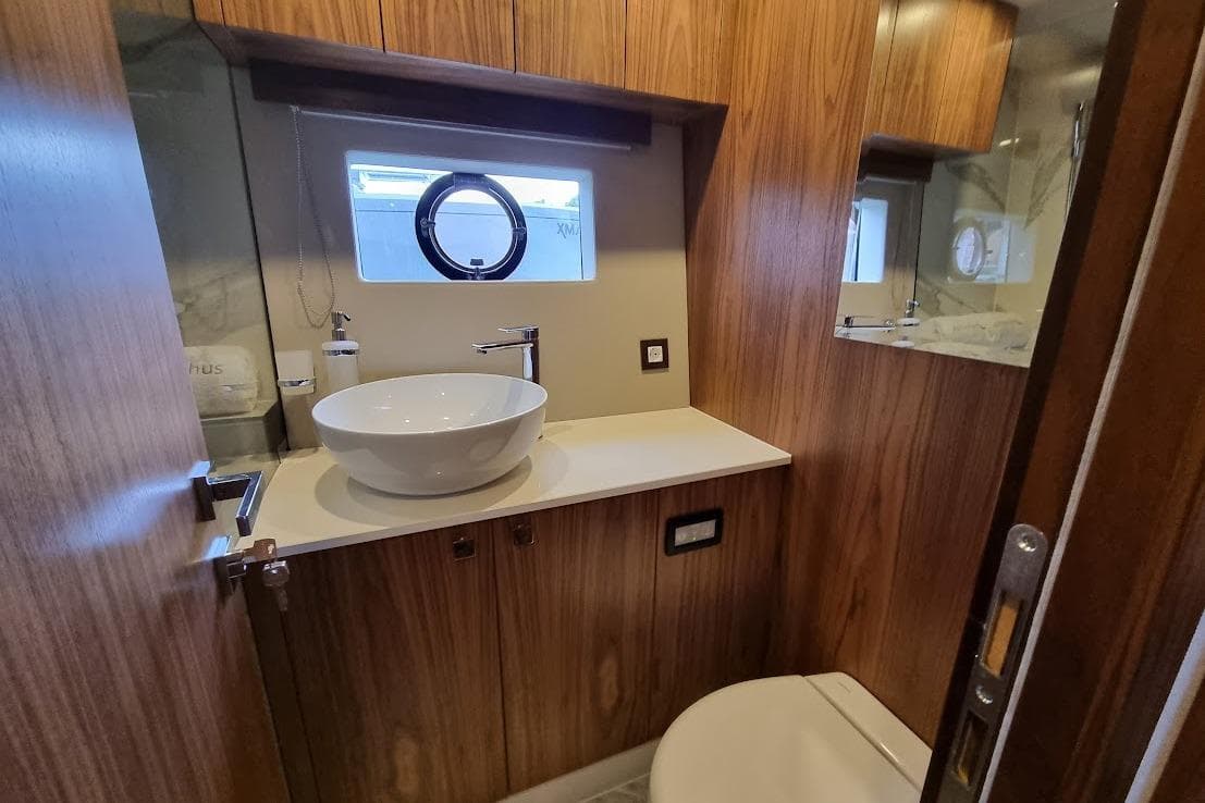 Luxurious bathroom in 2026 Monachus 70 Fly yacht with modern fixtures and wood paneling.
