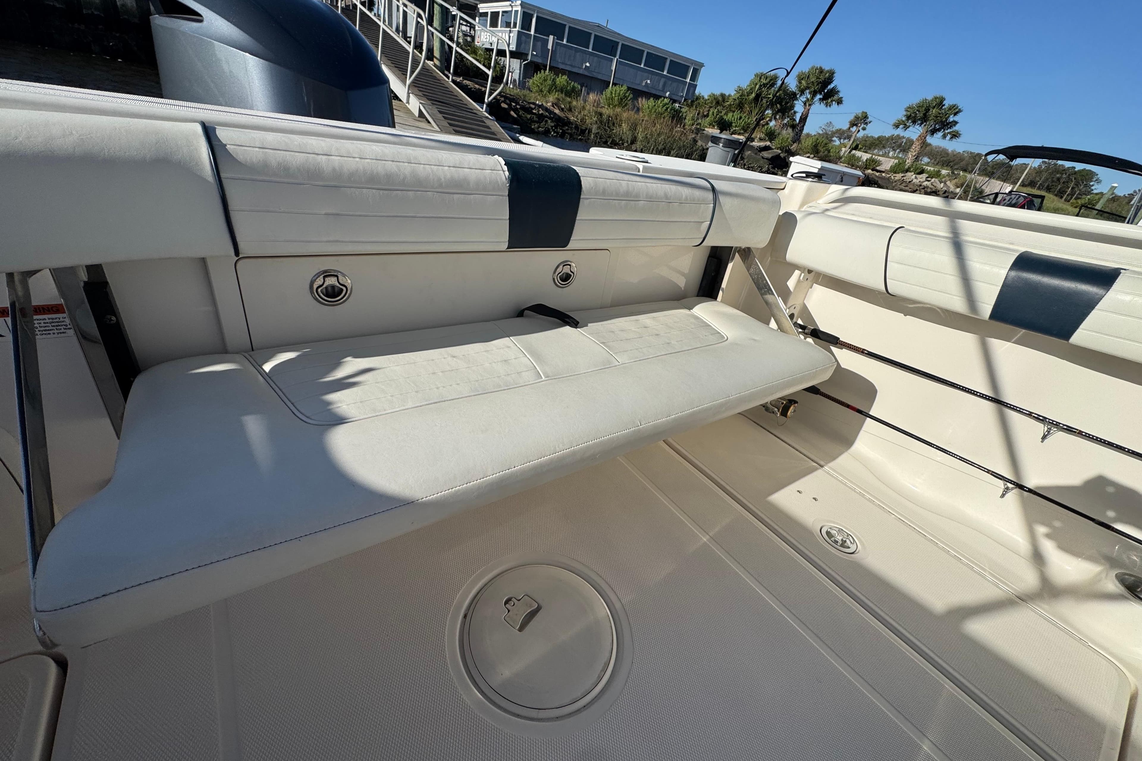 2014 Wellcraft 252 Coastal boat interior with white seating and storage compartments.