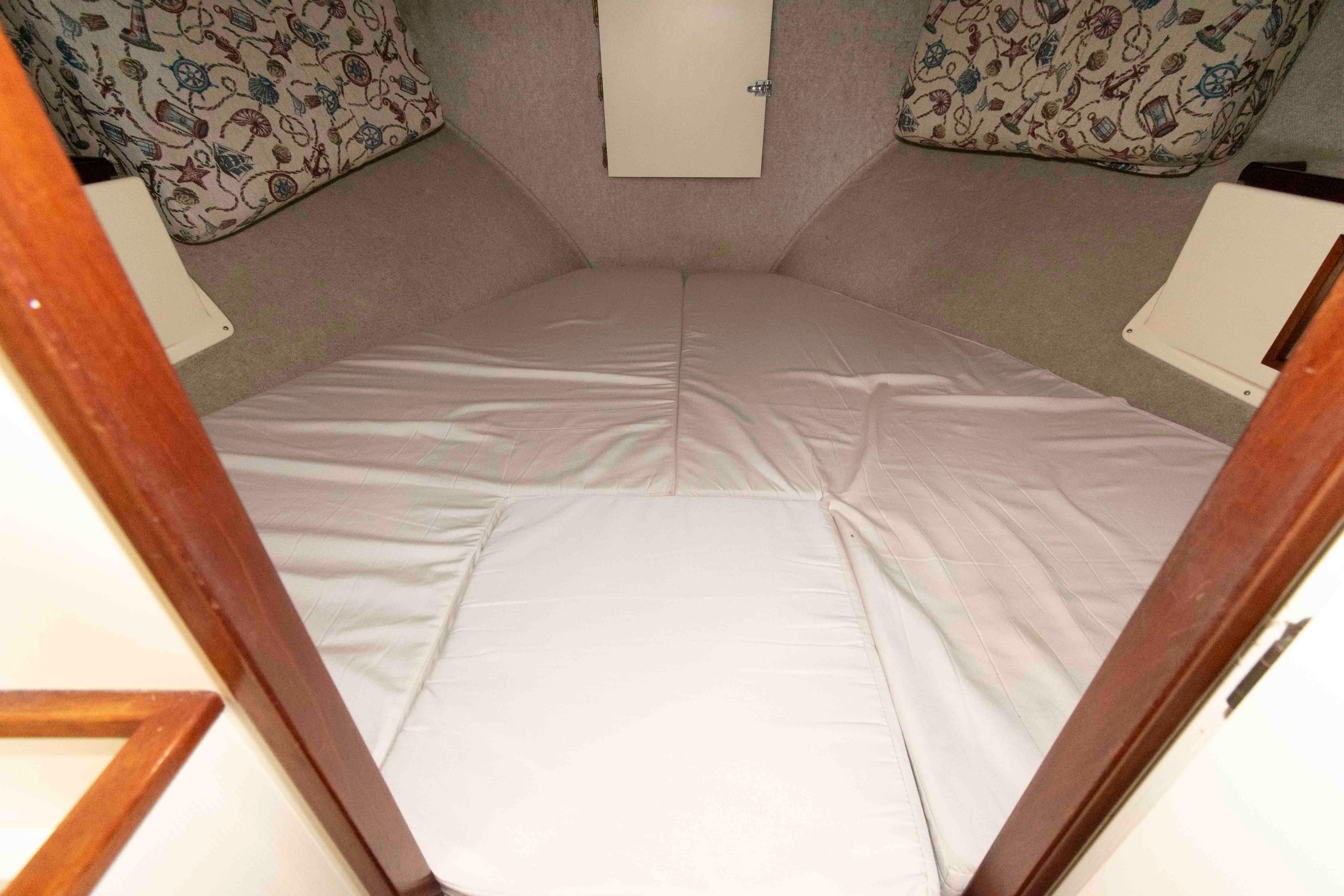 1999 Camano 31 Troll boat interior cabin with bed and nautical-themed cushions.