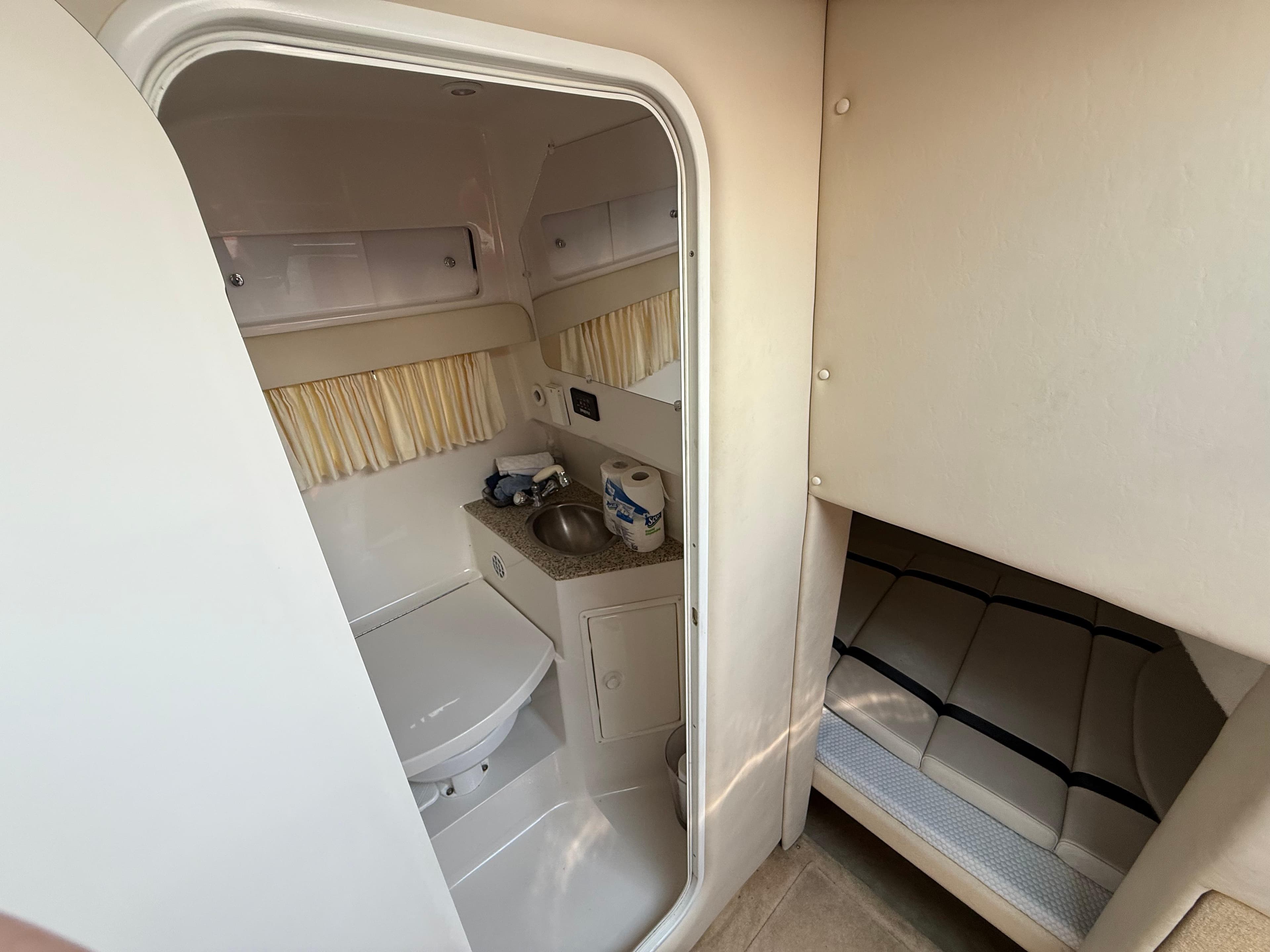 2005 Monterey 290SE boat interior with compact bathroom and cozy sleeping area.