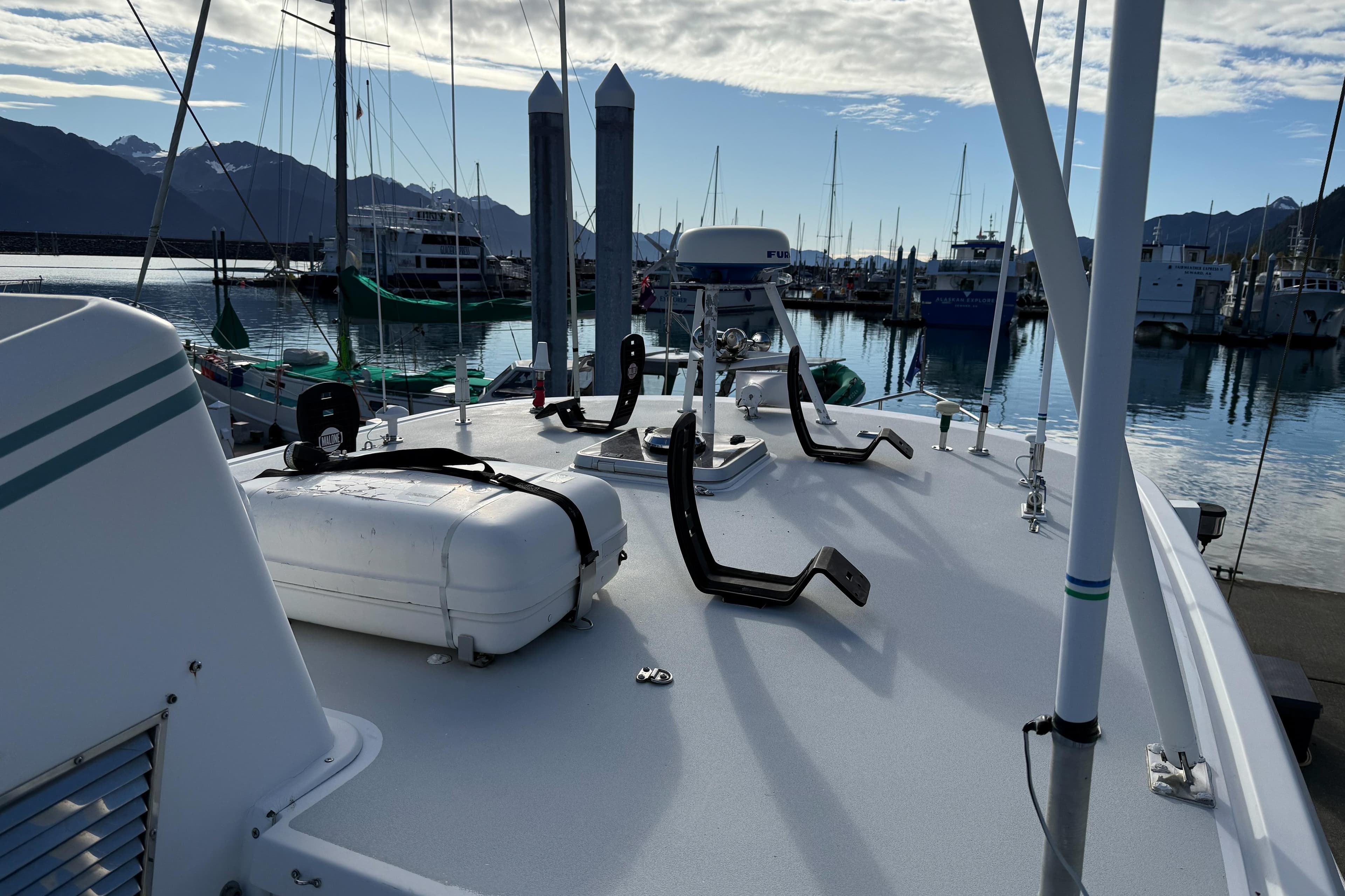 Nordhavn 46 yacht deck, 2001 model, docked in a marina with mountains in the background.