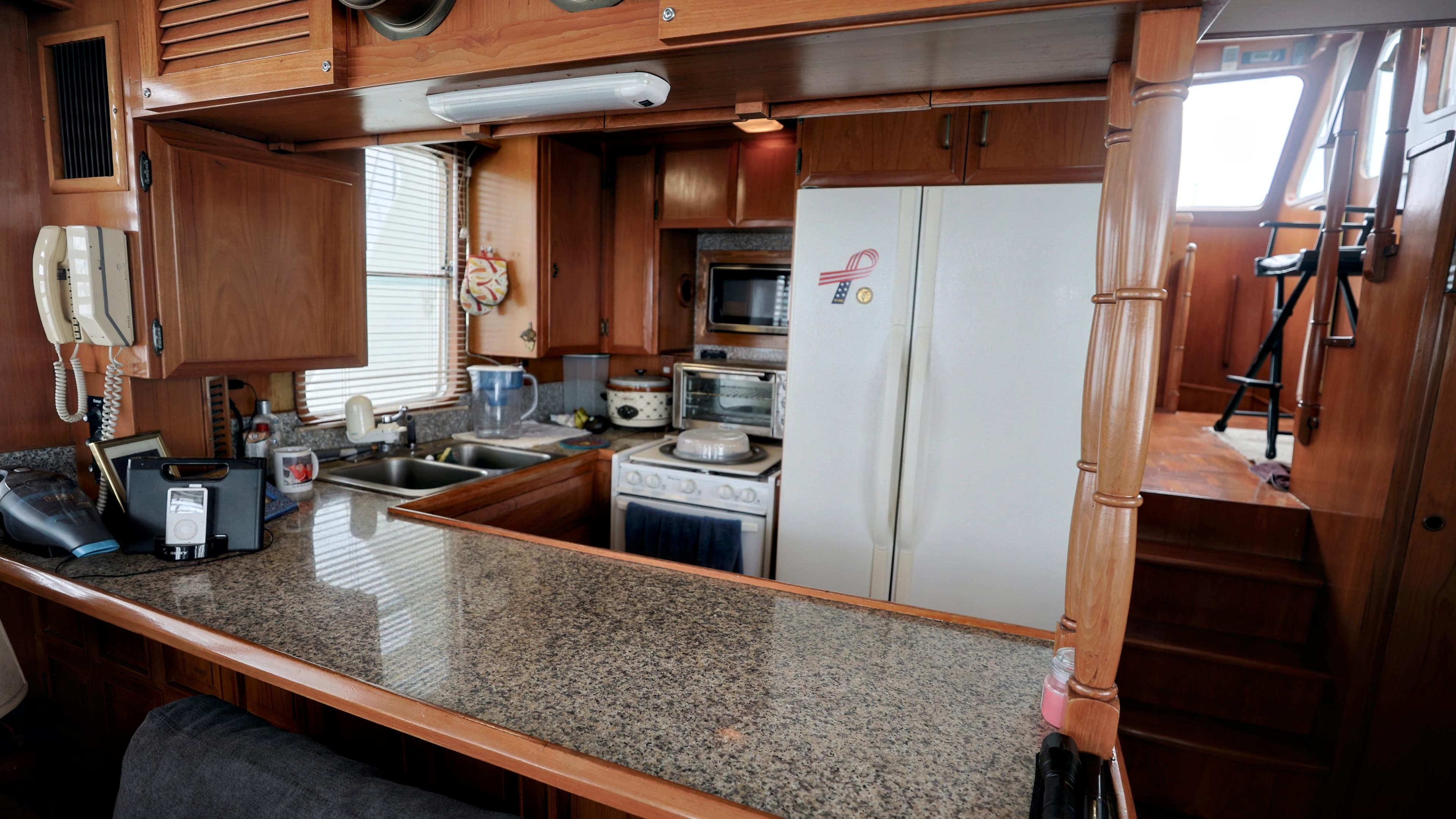 1988 DeFever Pilot House kitchen with granite countertop and wooden cabinetry.