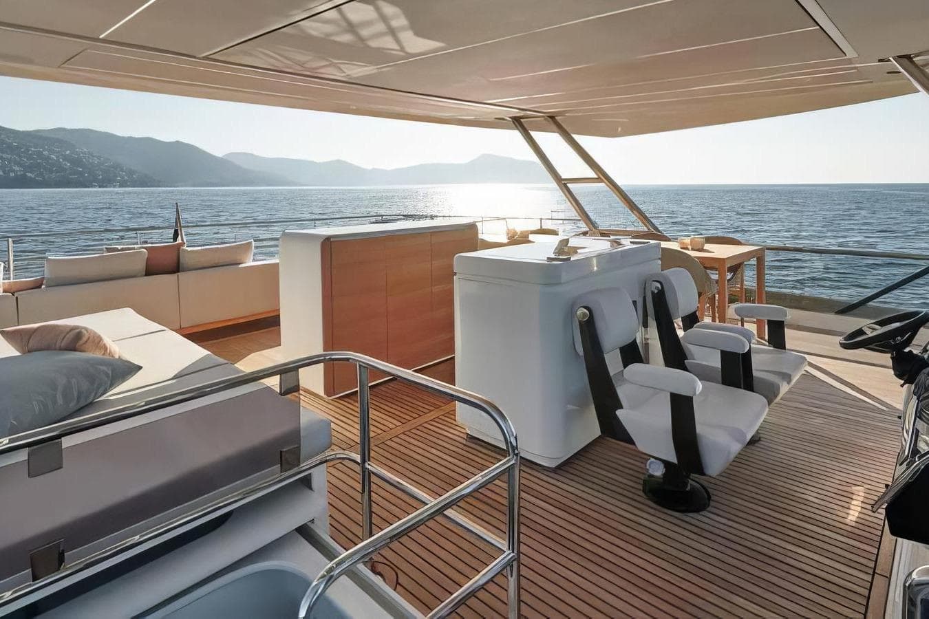 Luxurious 2026 Prestige yacht interior with modern seating, overlooking serene ocean and mountains.