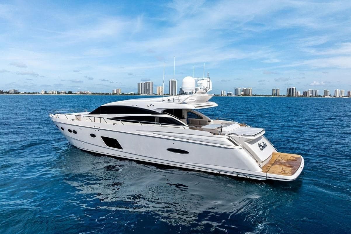 Luxurious 2013 Princess 78 yacht cruising on blue ocean near city skyline.