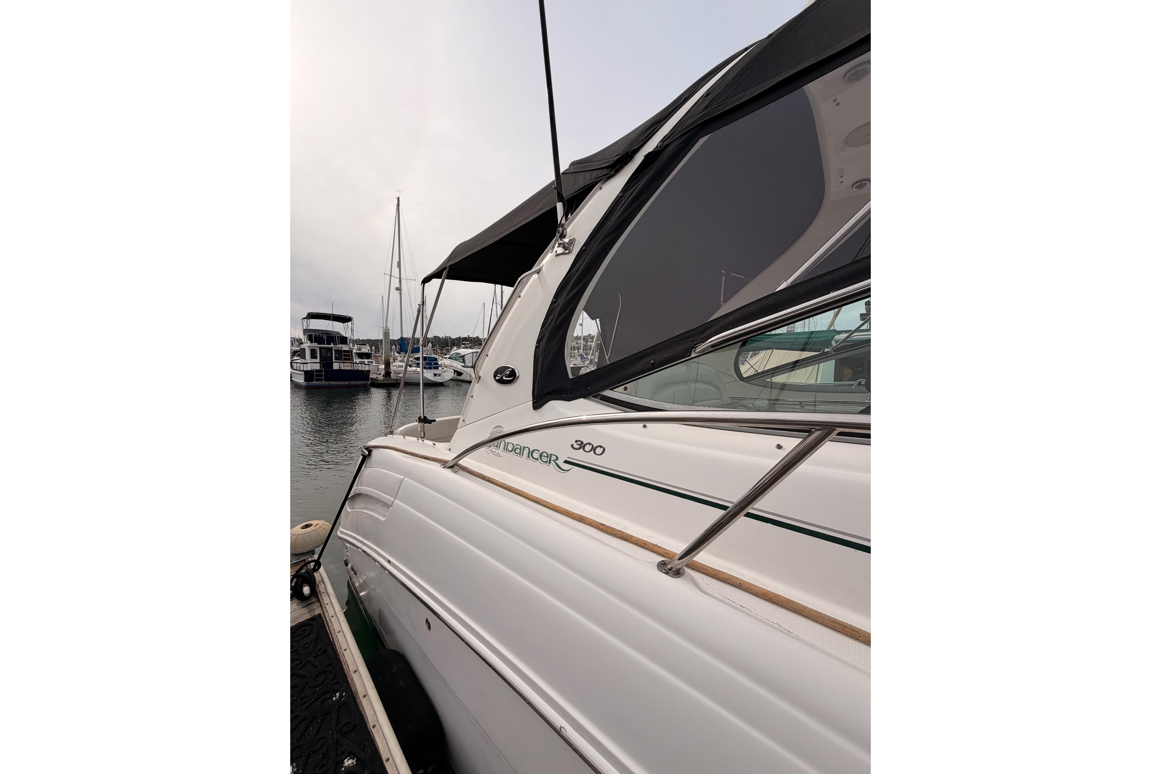 2005 Sea Ray 300 Sundancer docked at marina, side view.