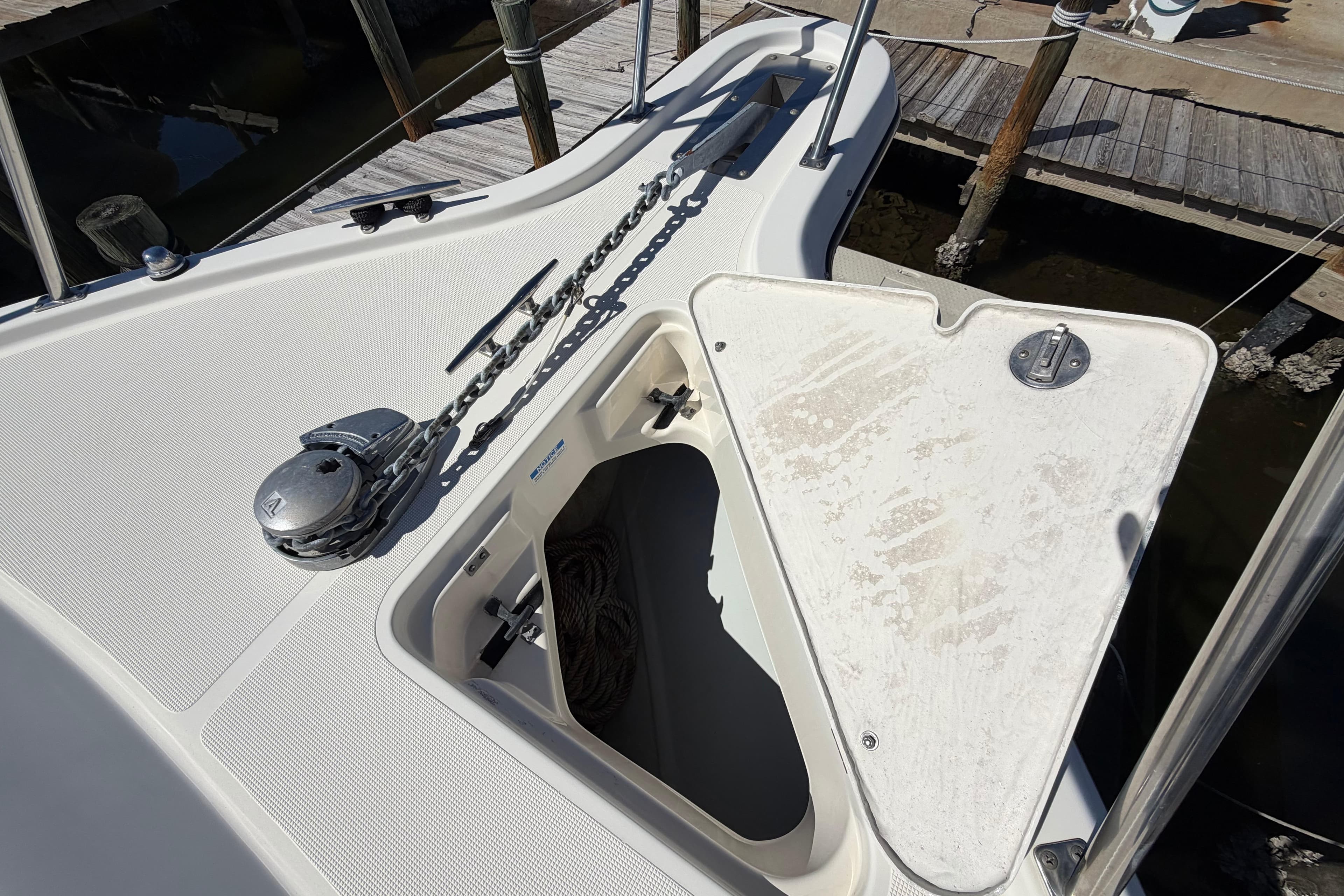 2001 Pursuit 3000 Express boat anchor locker with chain and winch at dock.