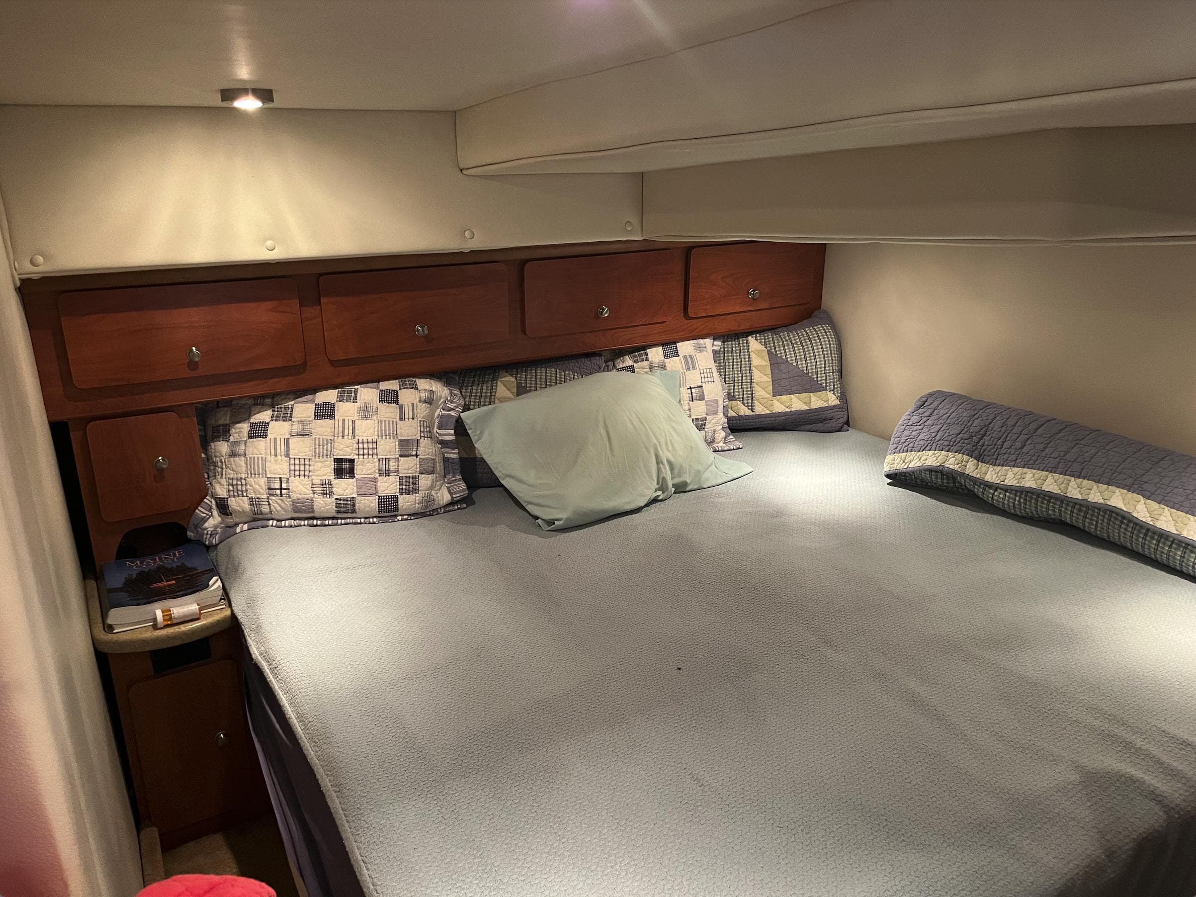 2006 Rinker 390 Express Cruiser cabin with bed, wooden cabinets, and soft lighting.