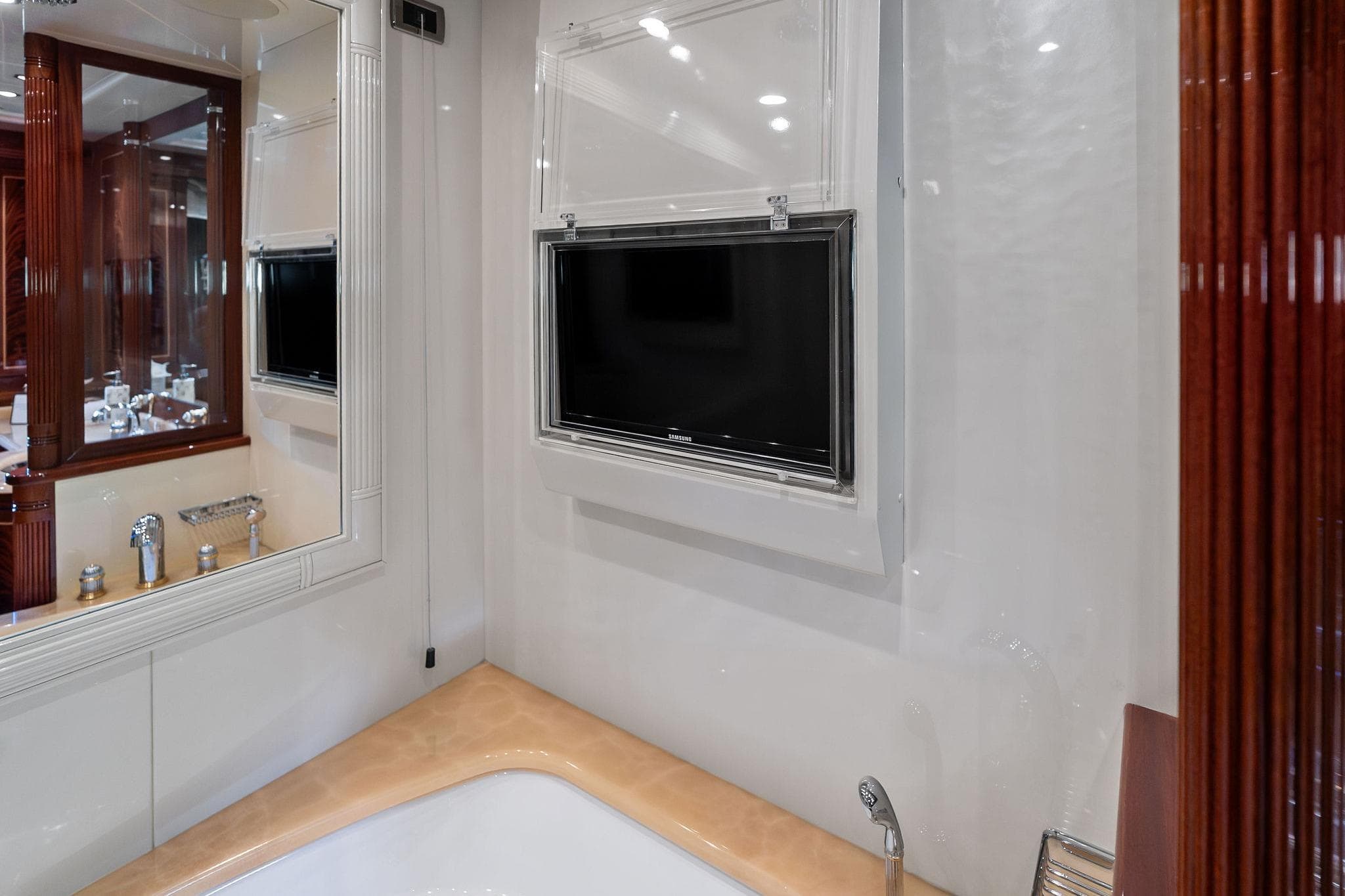 Luxurious bathroom interior on 2005 Mangusta 130 yacht with TV and elegant fixtures.