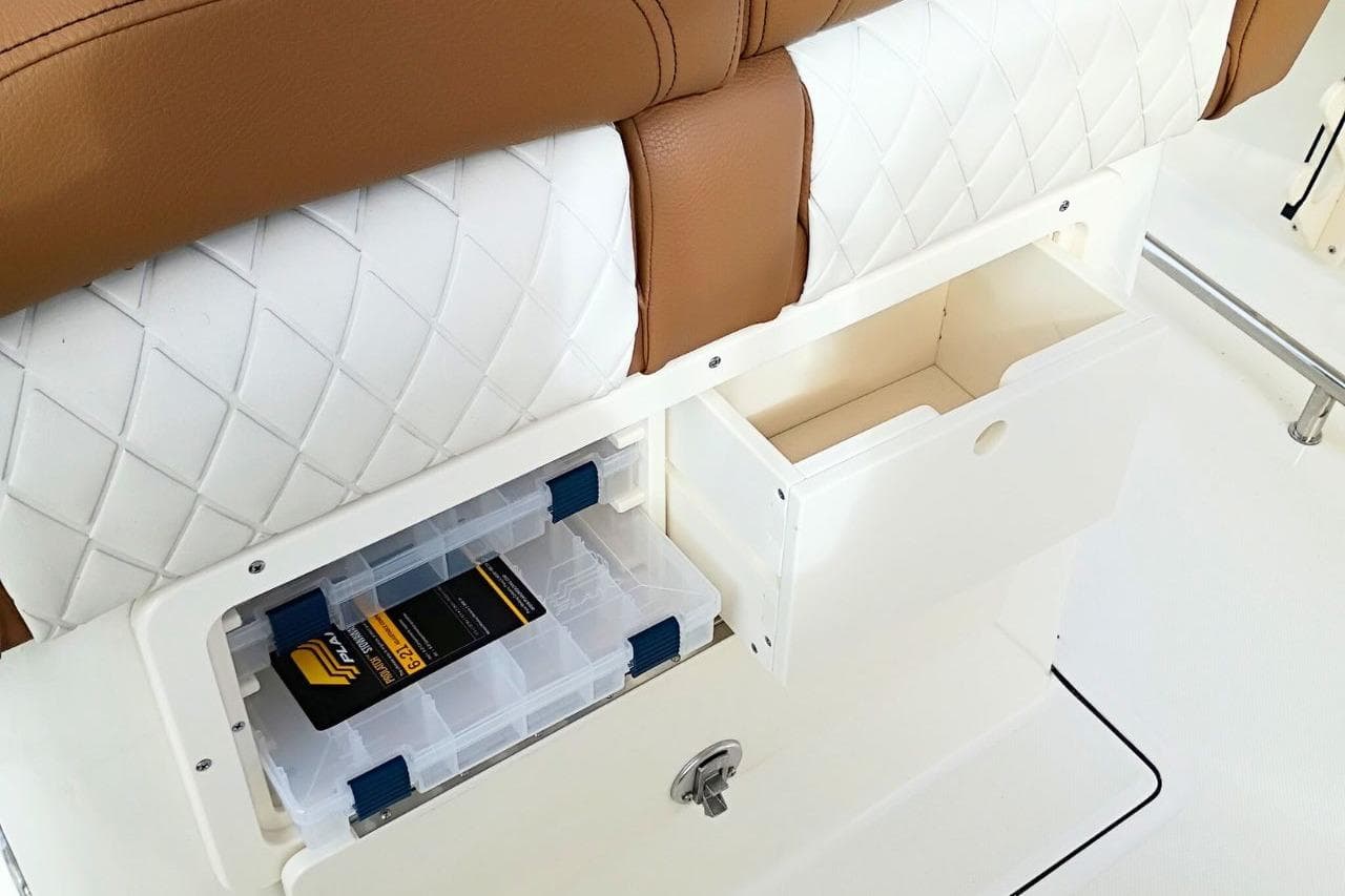 Storage compartments on 2026 Pioneer 202 Sportfish boat with cushioned seating.