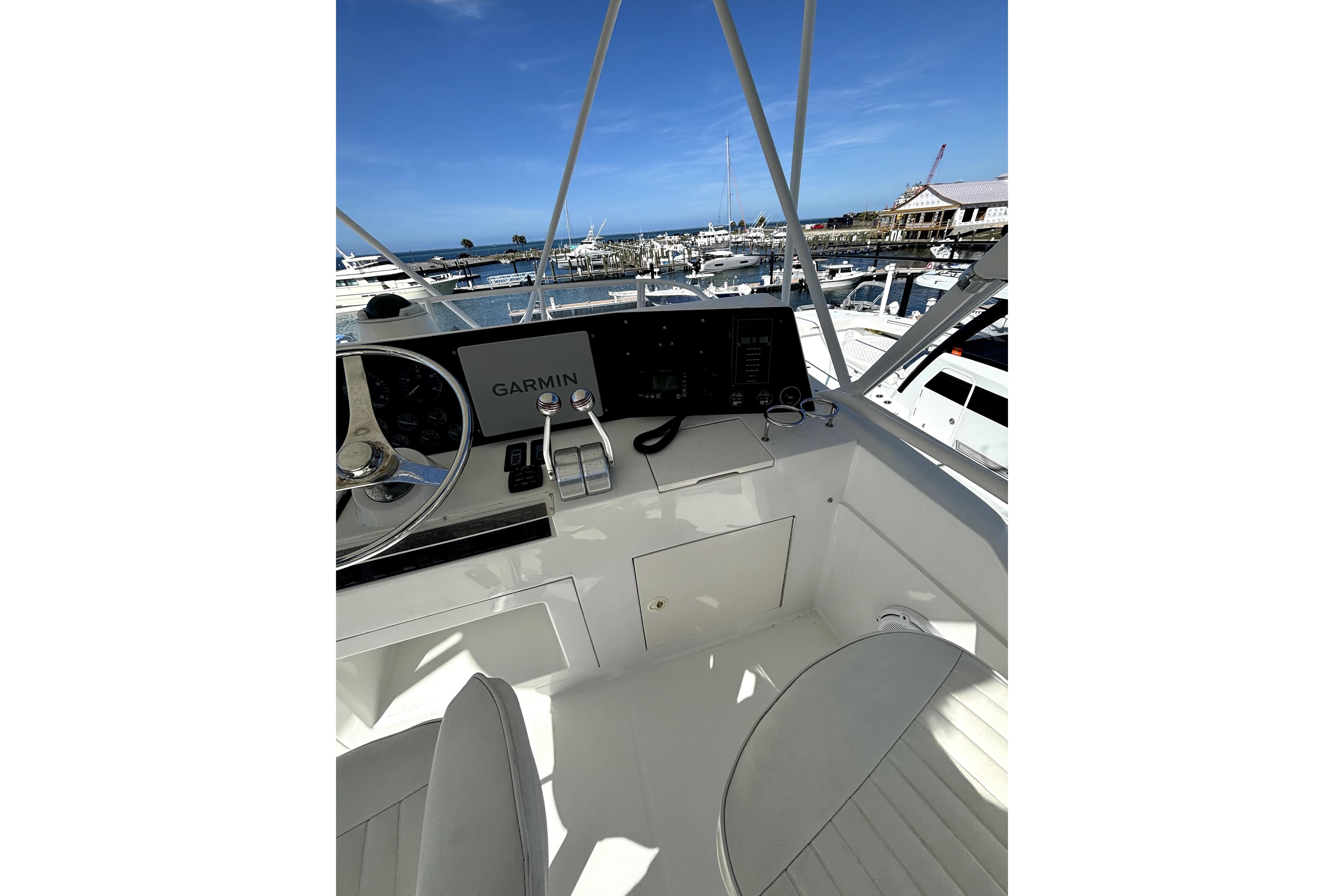 Helm of 2004 Jupiter 35 Convertible boat with Garmin navigation, docked at marina.