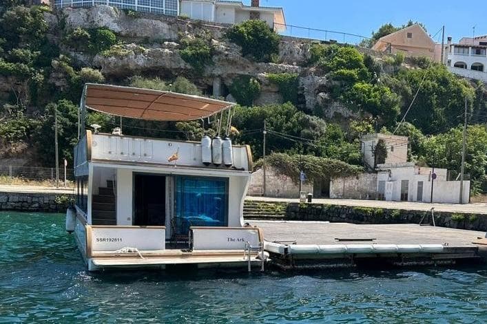 Houseboat docked by a scenic shoreline, Mardaya Tiburon 70, 2018 model.