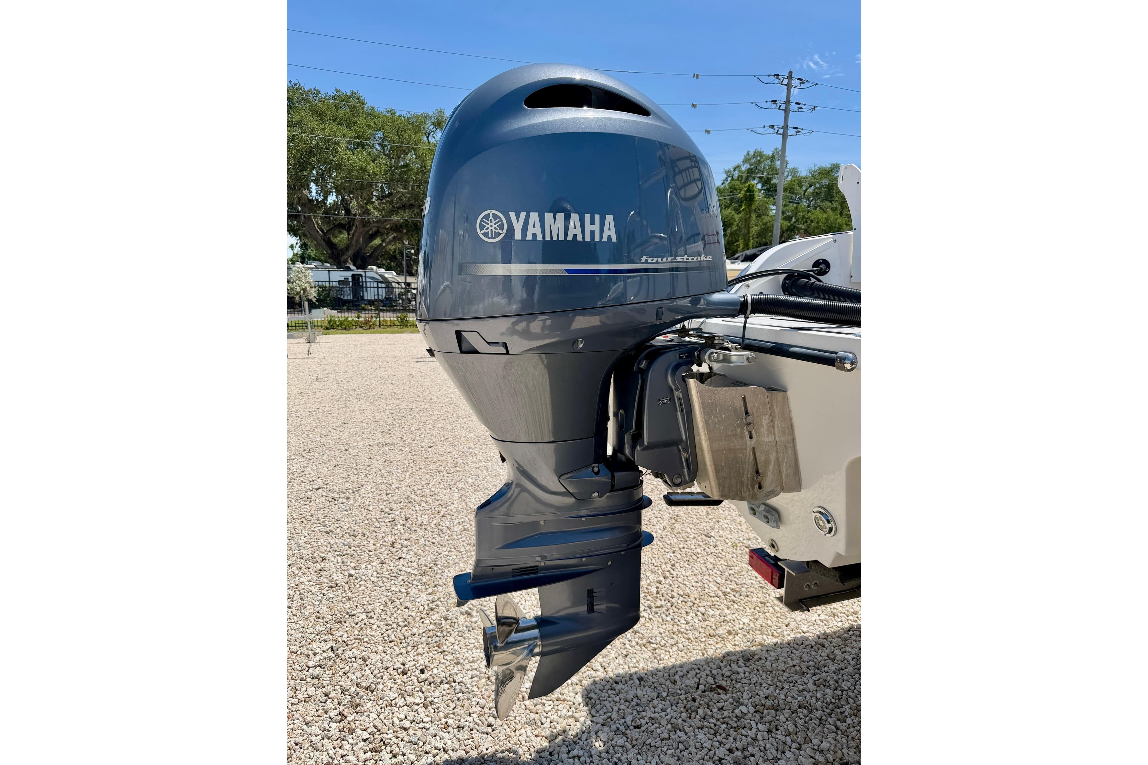 Yamaha outboard motor on 2021 Twin Vee 240 GFX DC boat, parked on gravel.