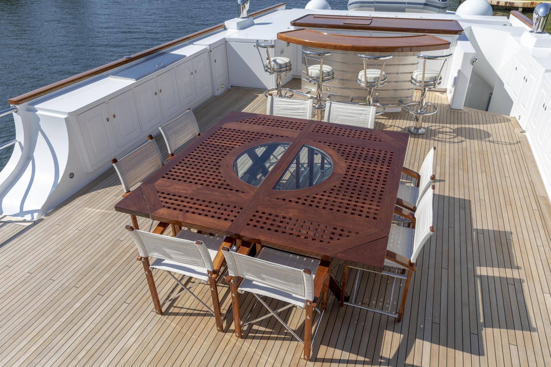 Luxurious yacht deck with wooden dining table and bar stools, Burger NADAN 2009 model.