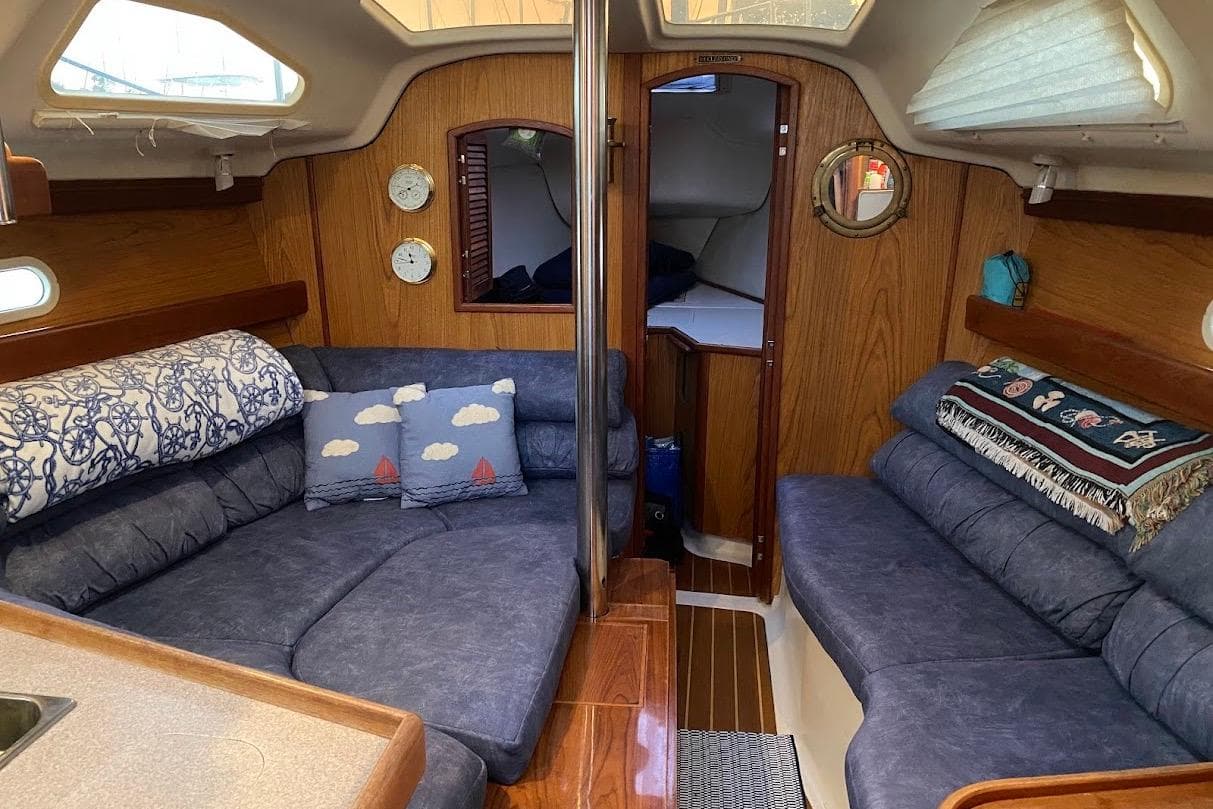 Interior of a 2000 Hunter 340 sailboat with cozy seating and nautical decor.