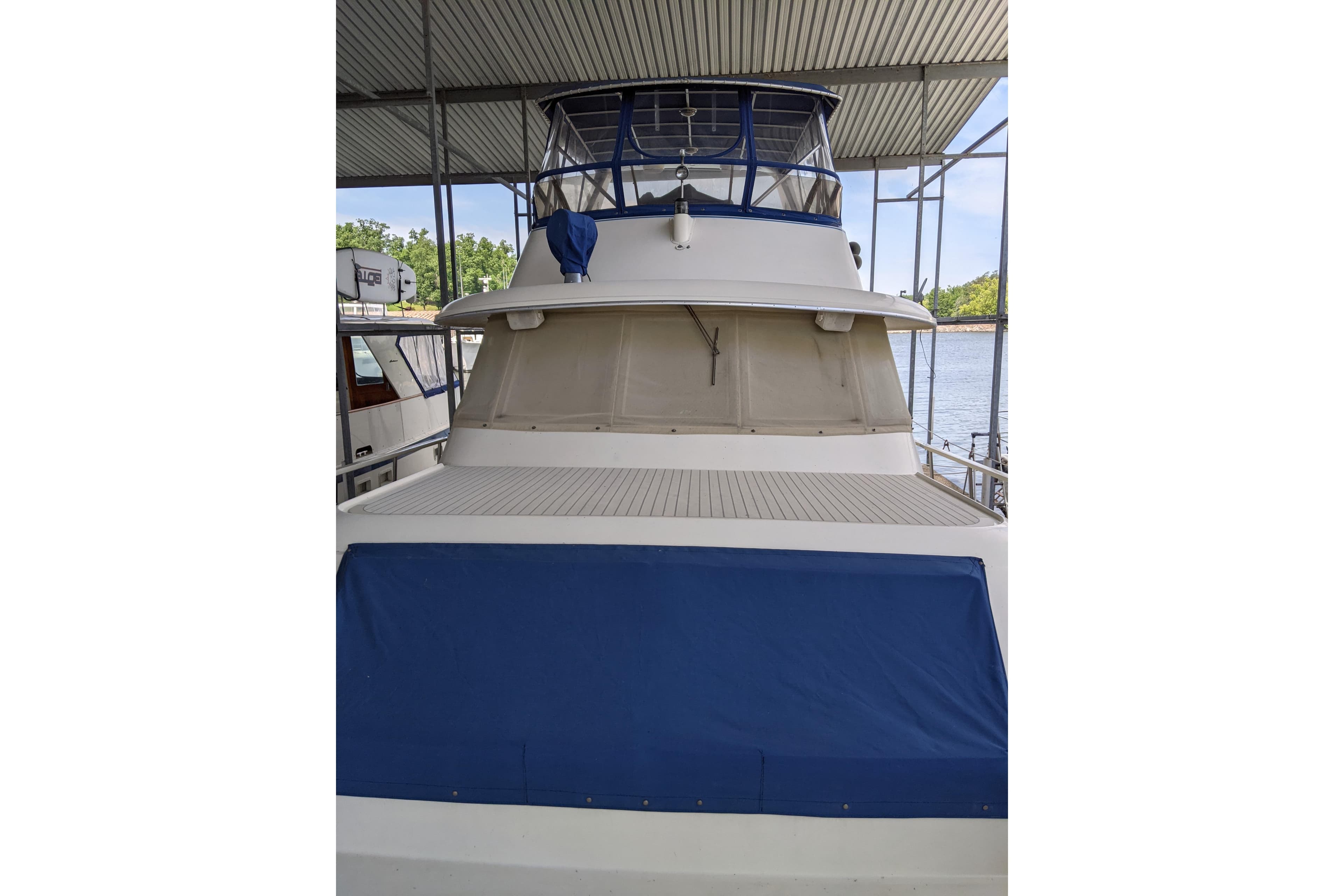 1984 Hatteras 53 Extended Deckhouse Motor Yacht docked under a covered marina.