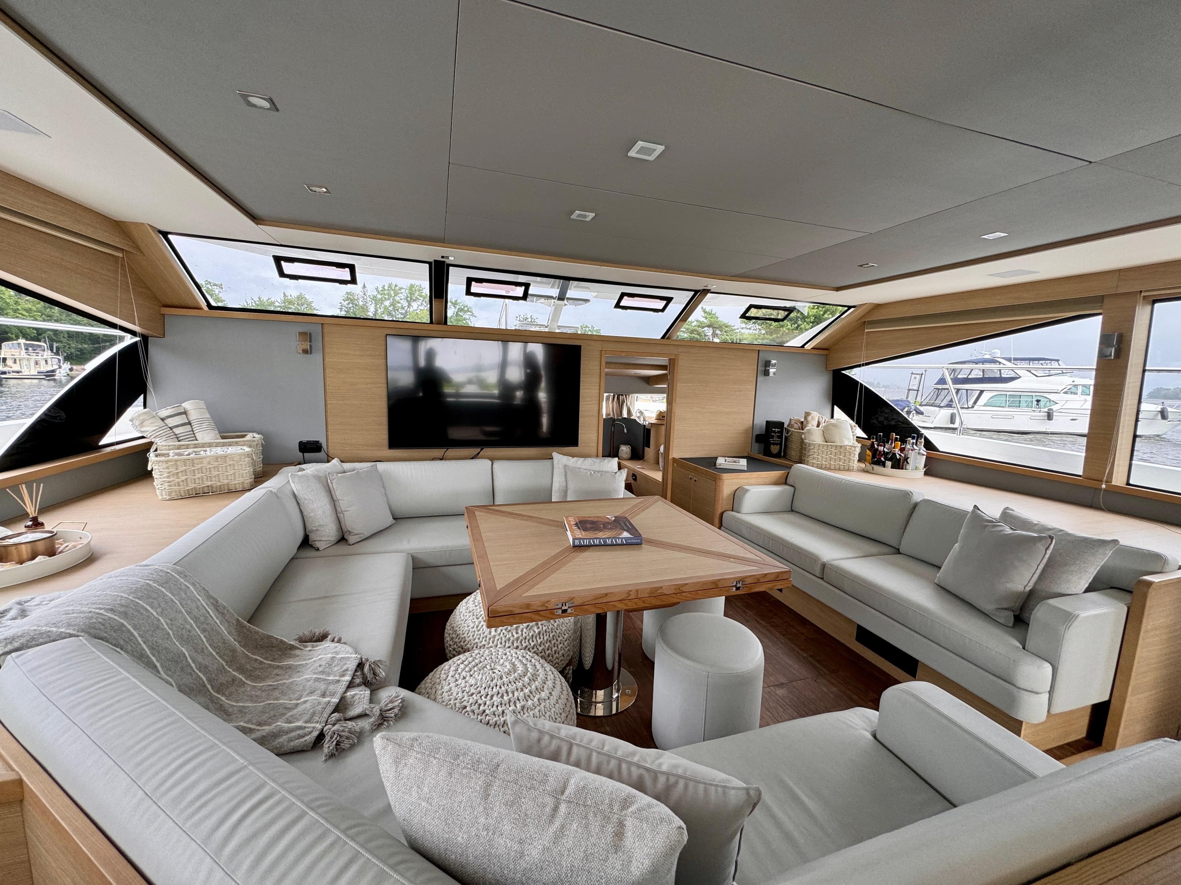 Luxurious interior of 2024 Aquila 54 Yacht with modern seating and large windows.