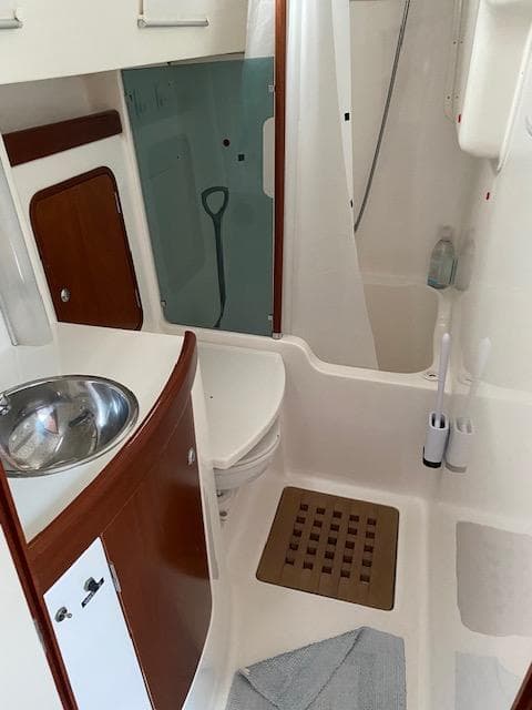 2001 Beneteau Oceanis 44 CC yacht bathroom with sink, shower, and wooden accents.