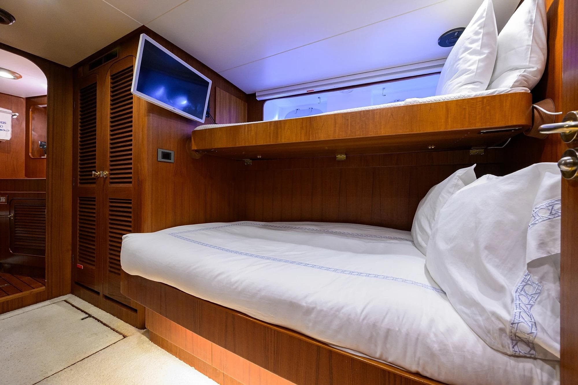 Luxurious cabin interior of 1986 Jongert 85 yacht with wooden bunk beds.