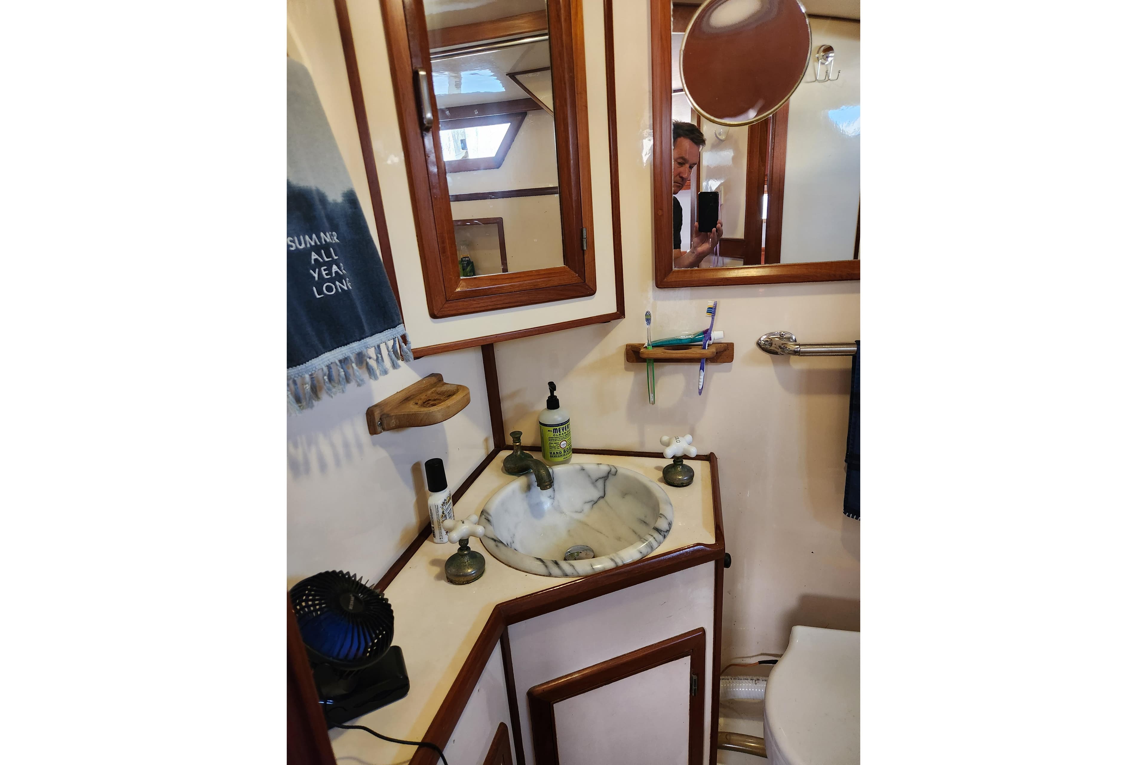 Bathroom interior of 1987 Jefferson 42 SE Sundeck Motor Yacht with sink and mirror.