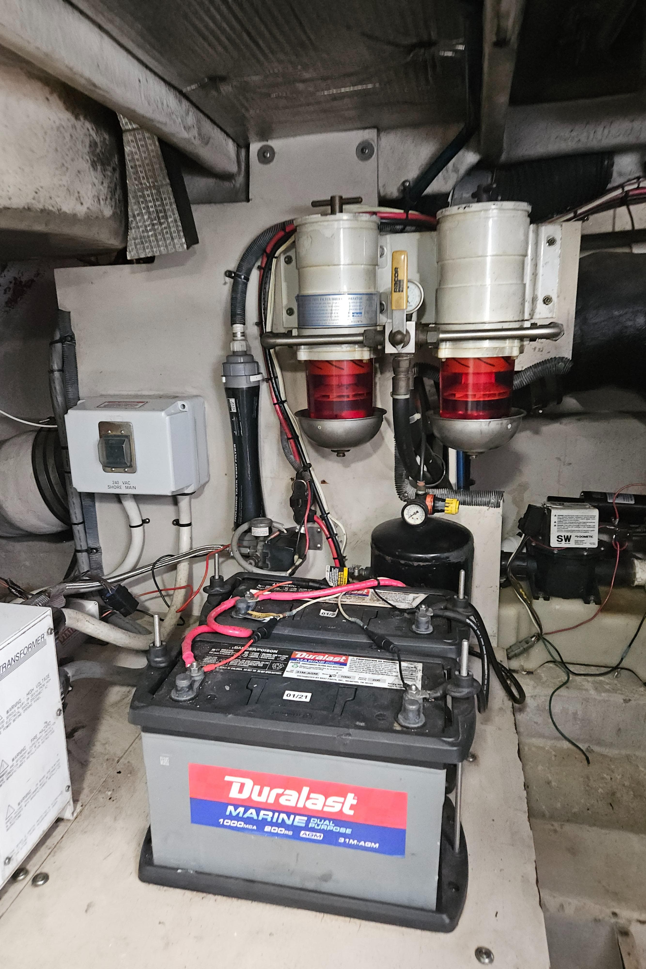 Engine room of 2005 Sea Ray 500 Sundancer with Duralast marine battery and fuel filters.