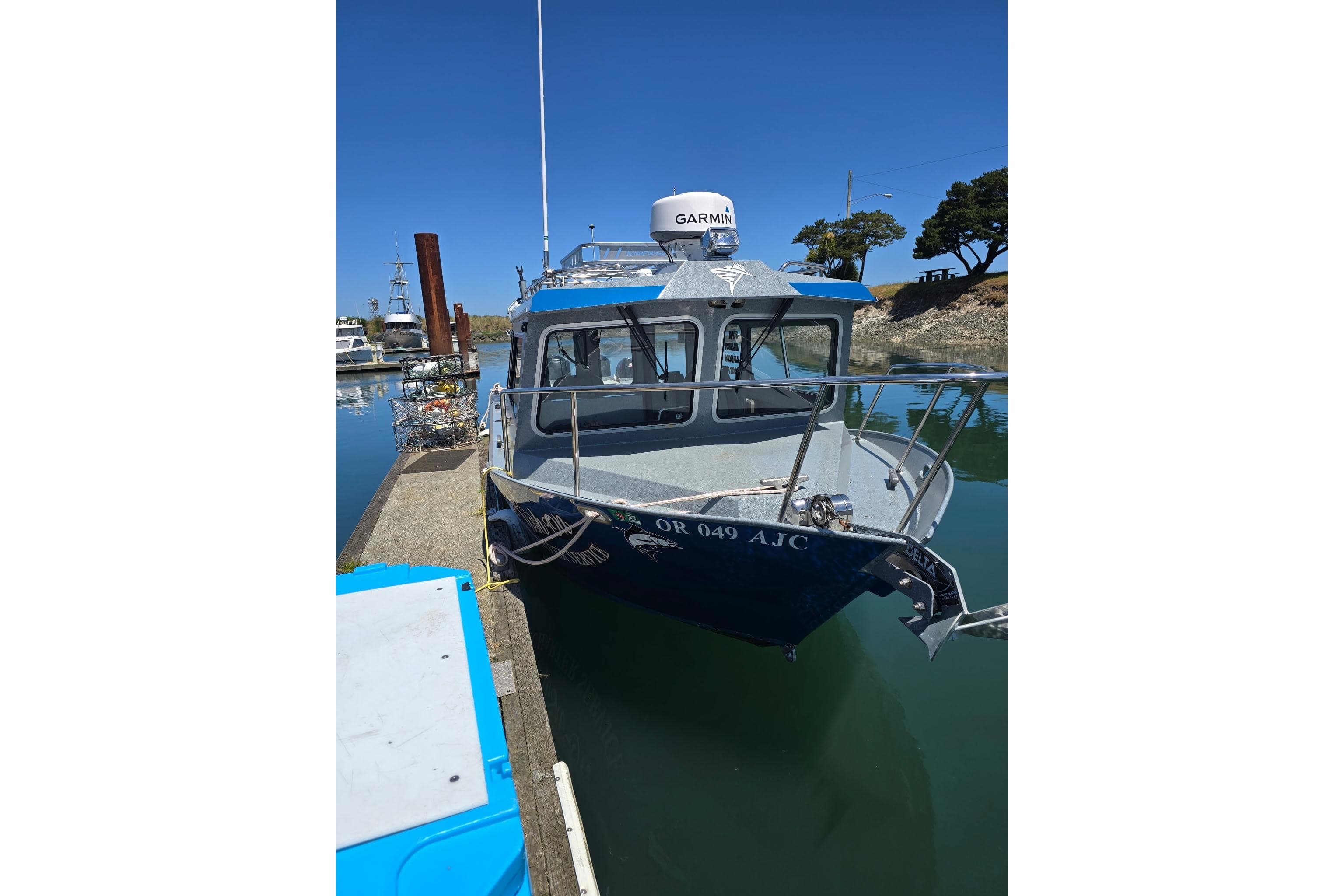 2021 KingFisher 2825 Coastal Express boat docked in a marina under clear blue sky.