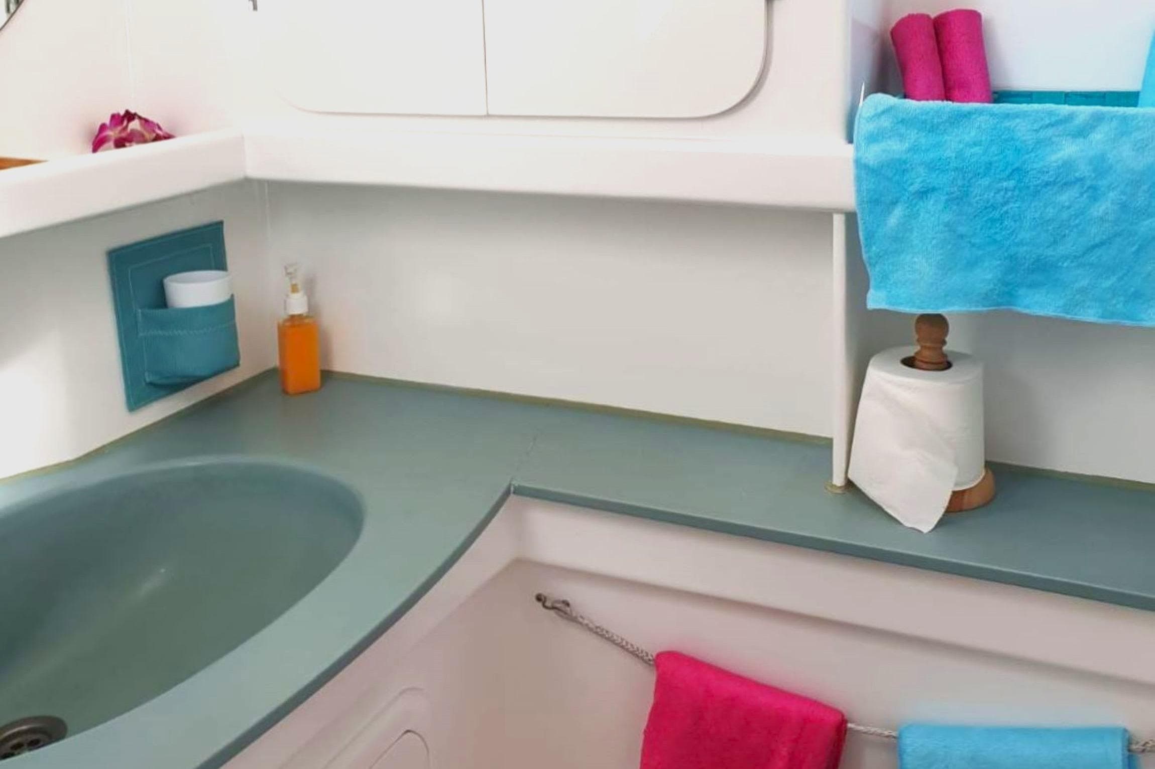 Bathroom interior of 2003 Multicap Caraibes PUNCH 1500 LC yacht, featuring sink and colorful towels.