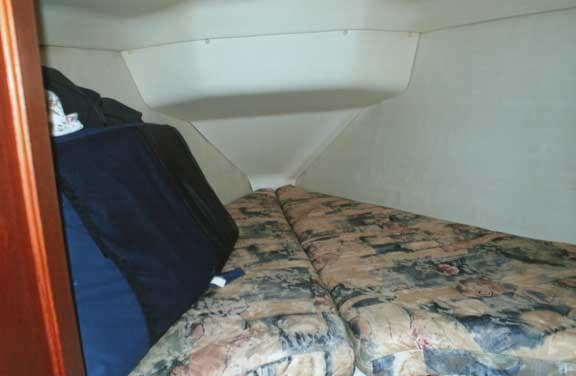 Cozy cabin interior of 1999 Hunter 380 sailboat with patterned bedding.