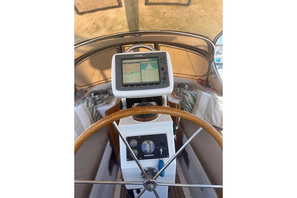 1986 Liberty 49 yacht helm with navigation system and wooden steering wheel.